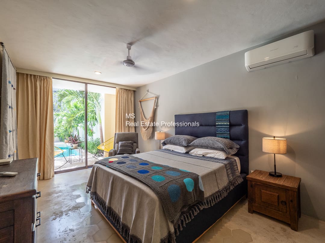 Bedroom with pool view and patio.
