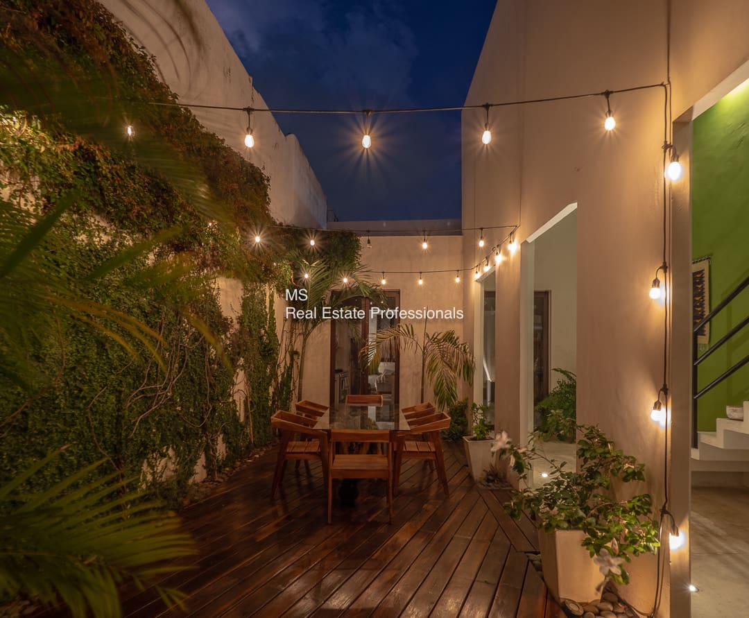 Nighttime patio with string lights and plants.