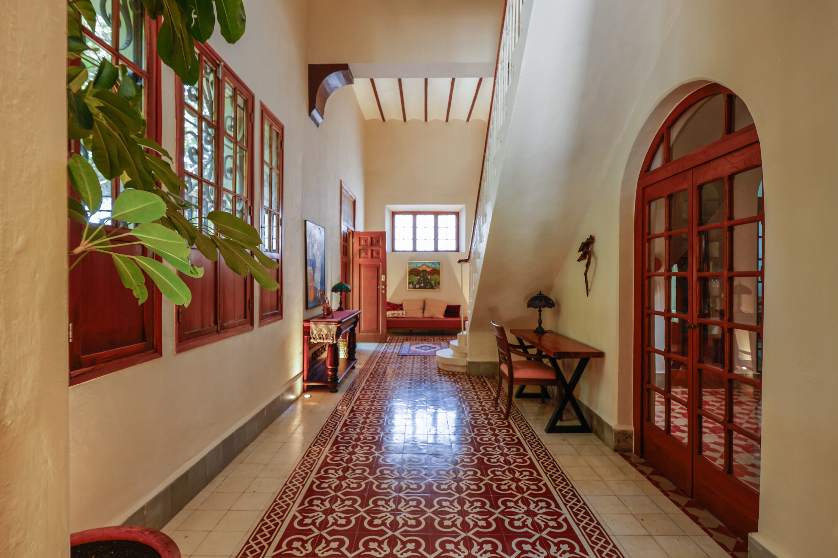 Ornate hallway with red tile floor.
