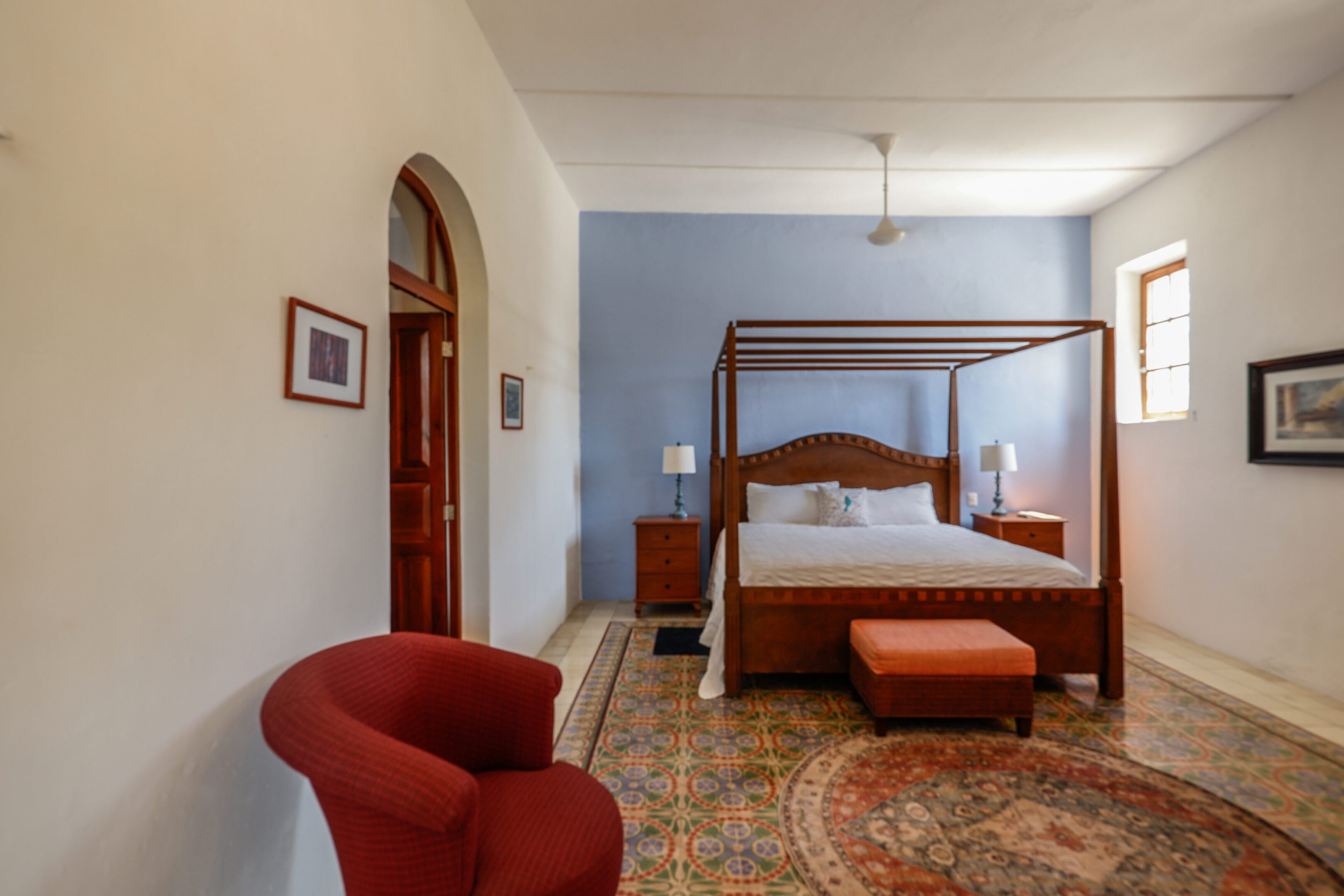 Bedroom with four-poster bed and rug.