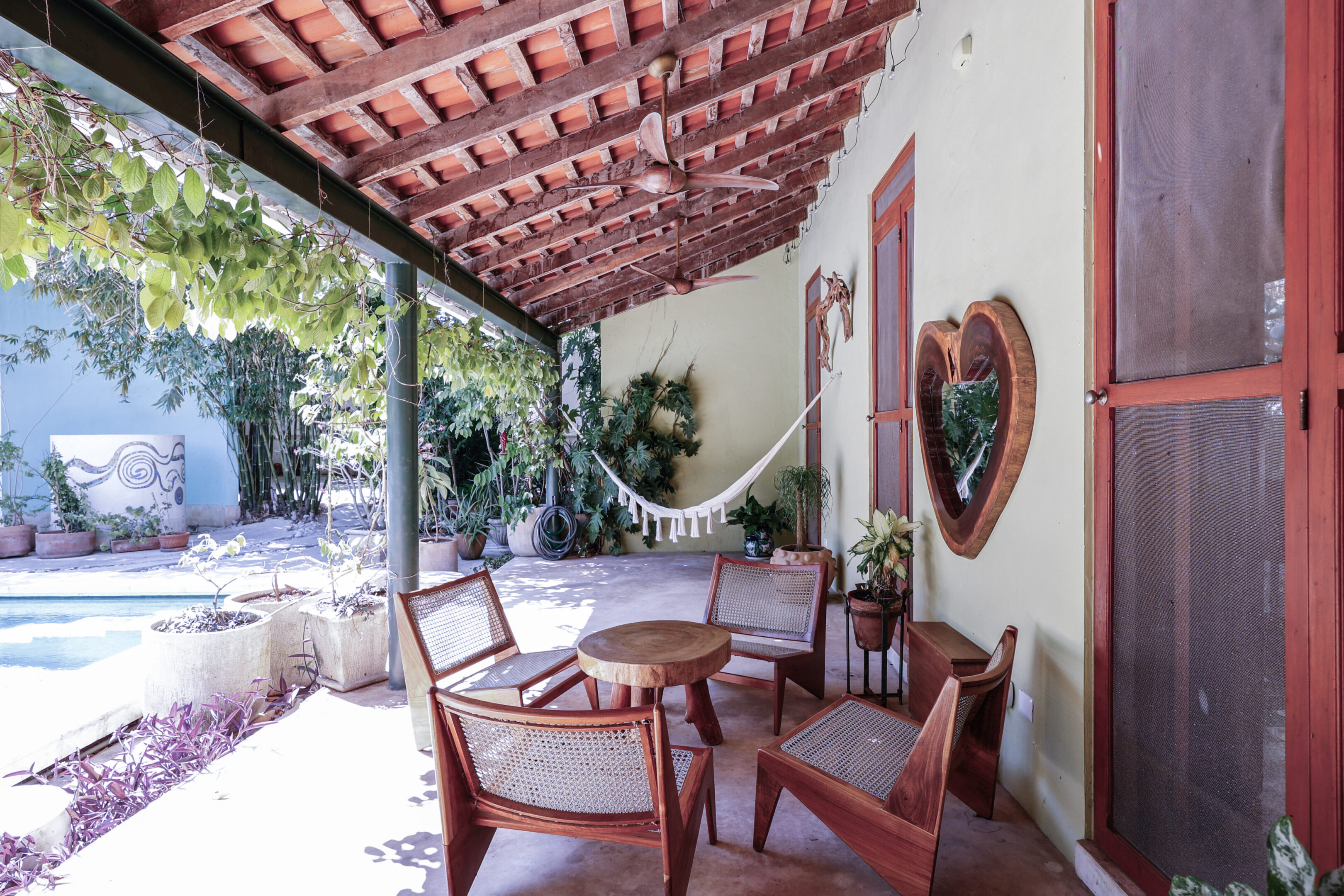 Covered patio with wooden furniture and hammock.