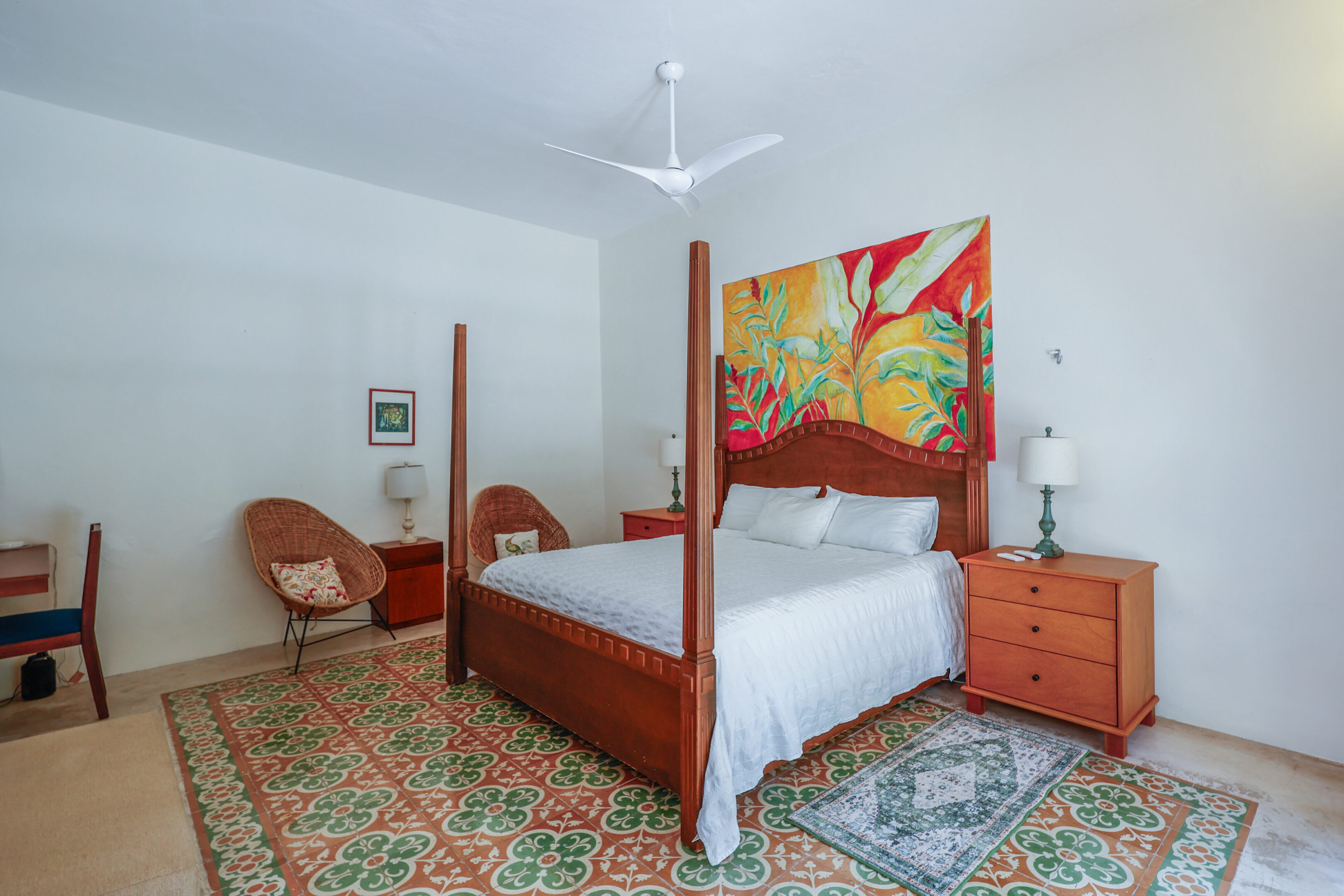 Bedroom with four-poster bed and artwork.