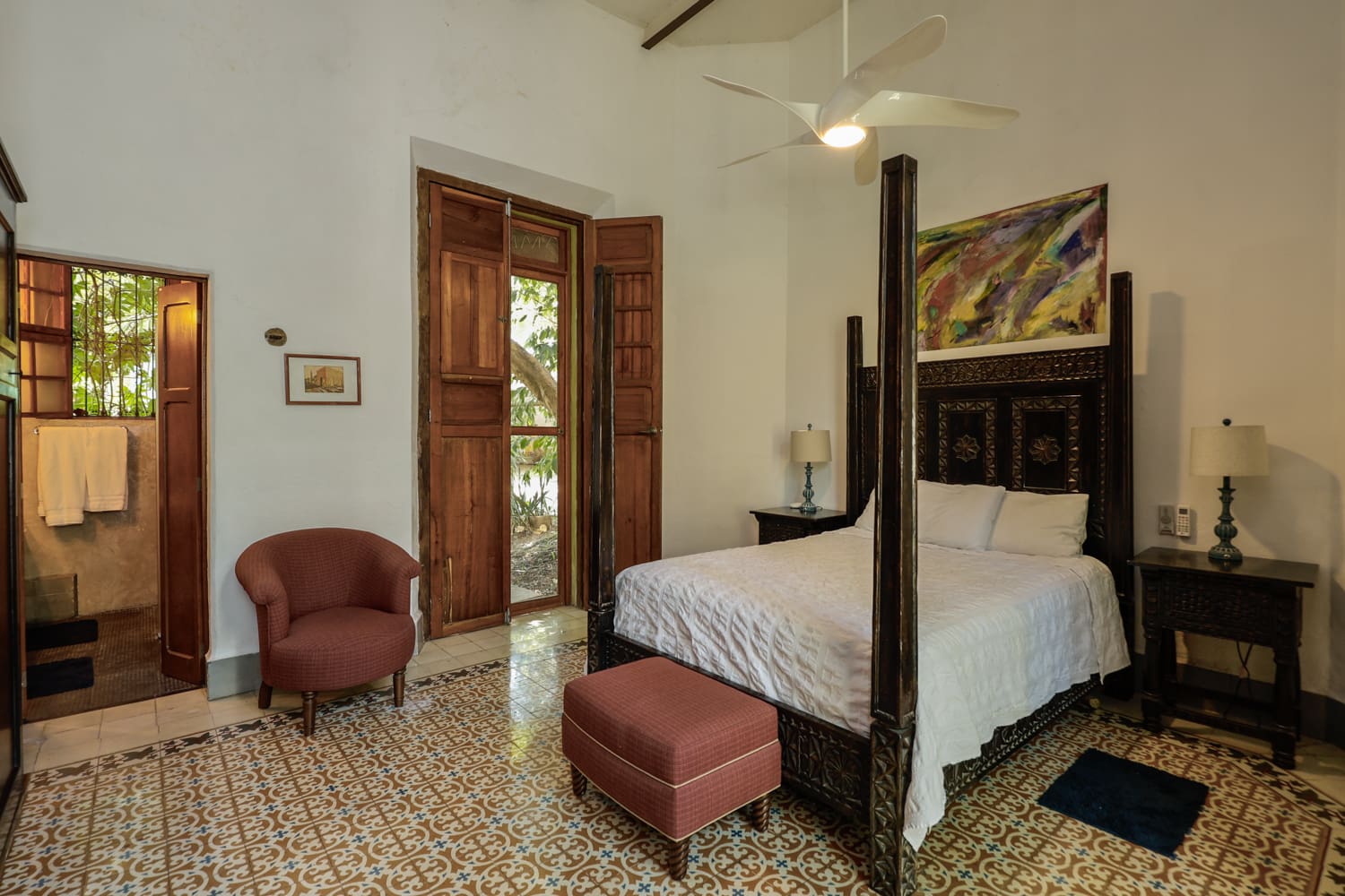 Bedroom with four-poster bed and tiled floor.