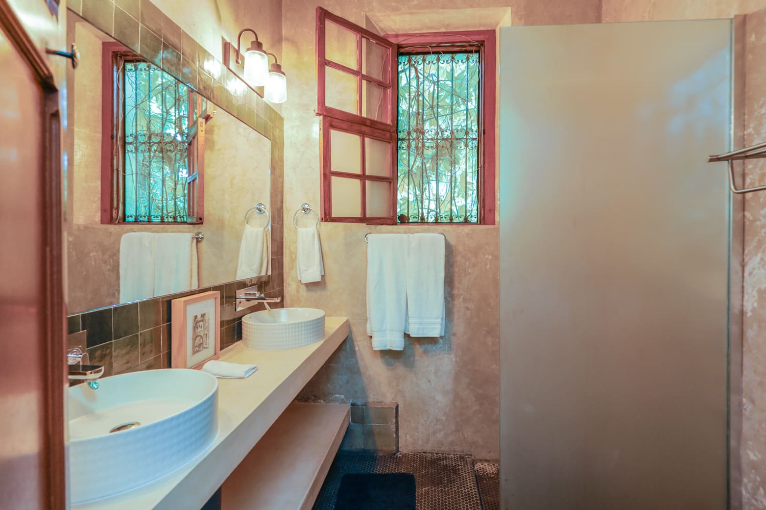 Rustic bathroom with double sinks and shower.