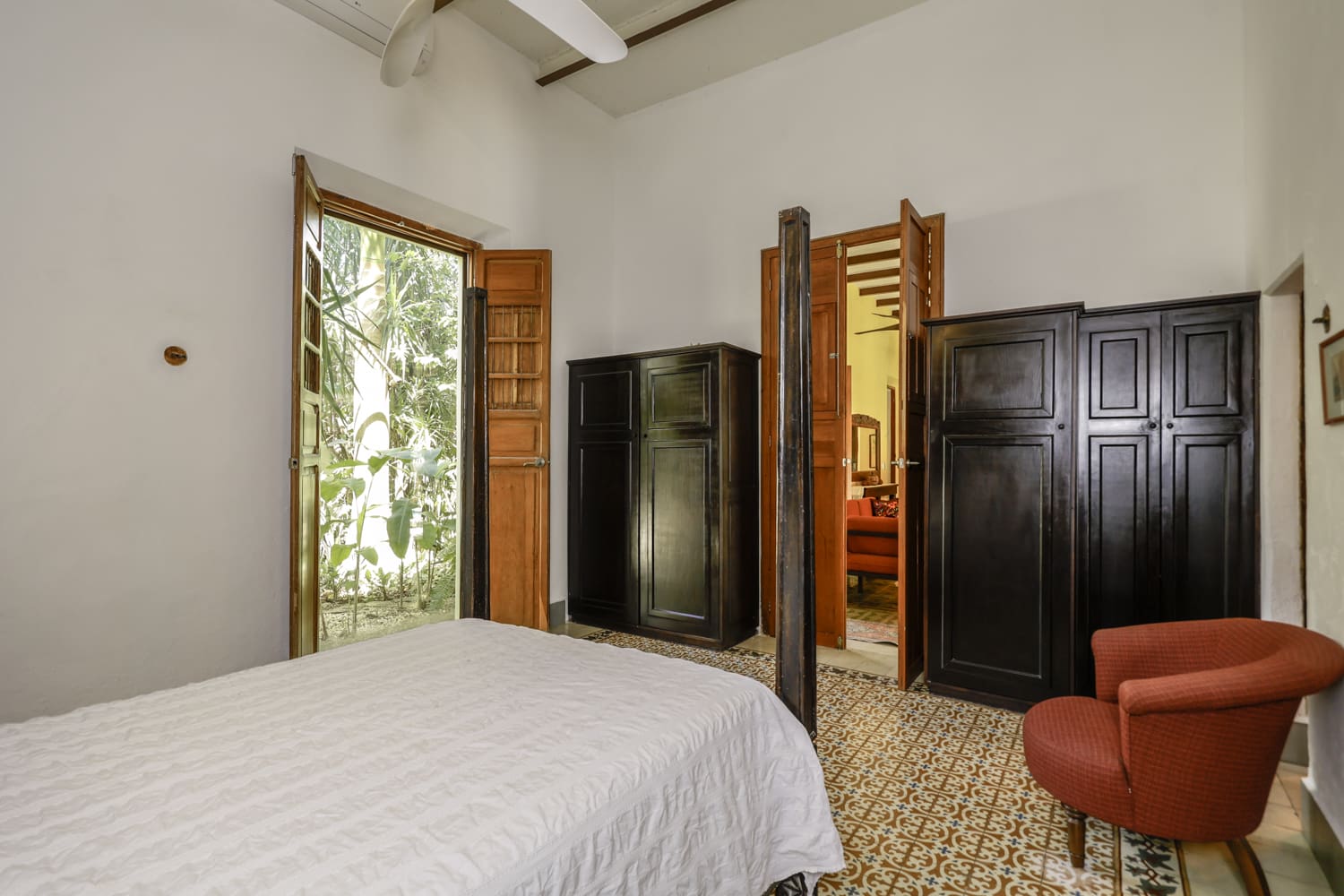 Bedroom with white bed and dark wardrobe.