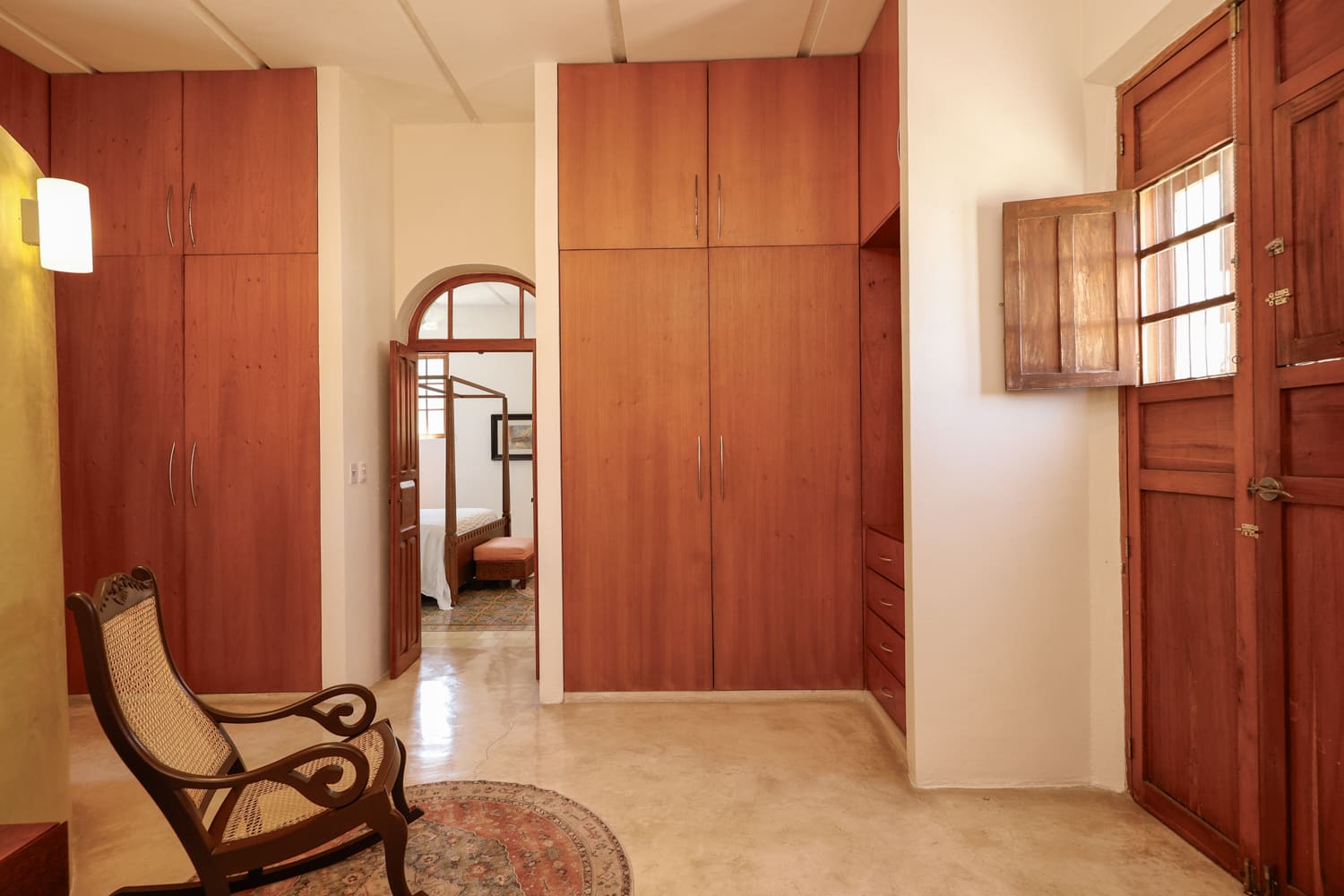 Bedroom with wooden closets and chair.
