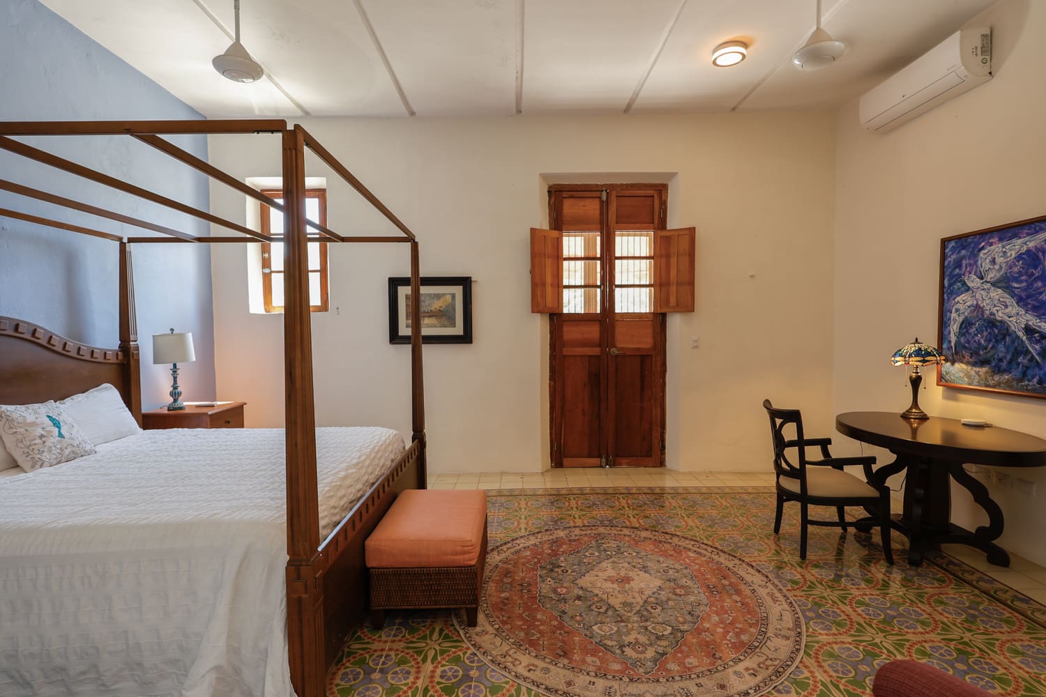 Bedroom with four-poster bed and rug.