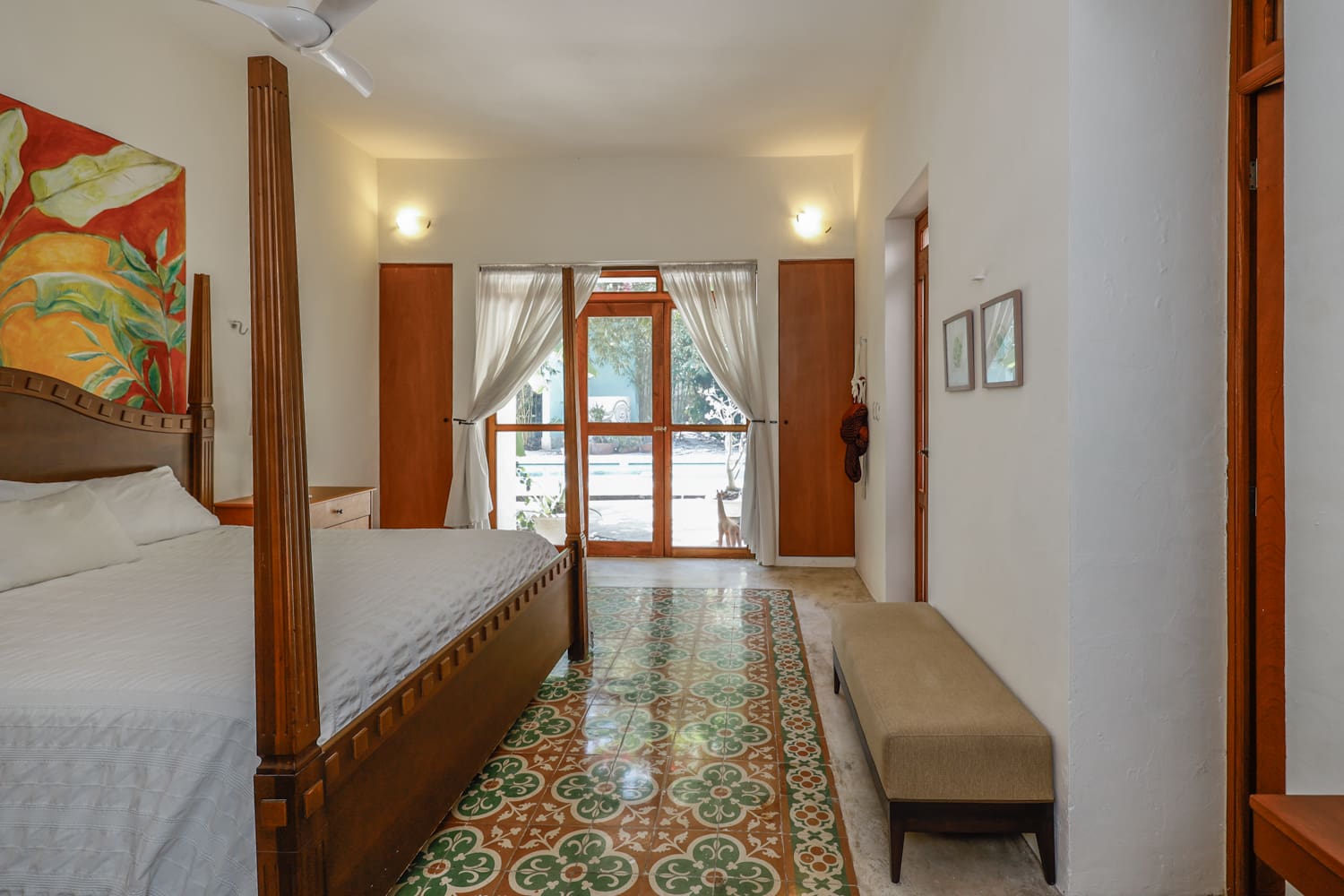 Bedroom with four-poster bed and patio doors.