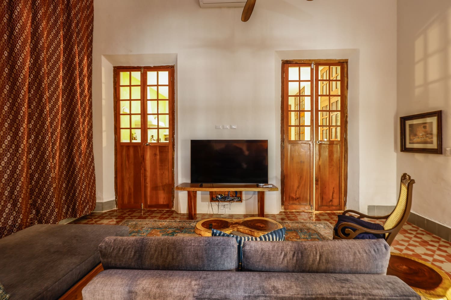Living room with TV and wooden doors.