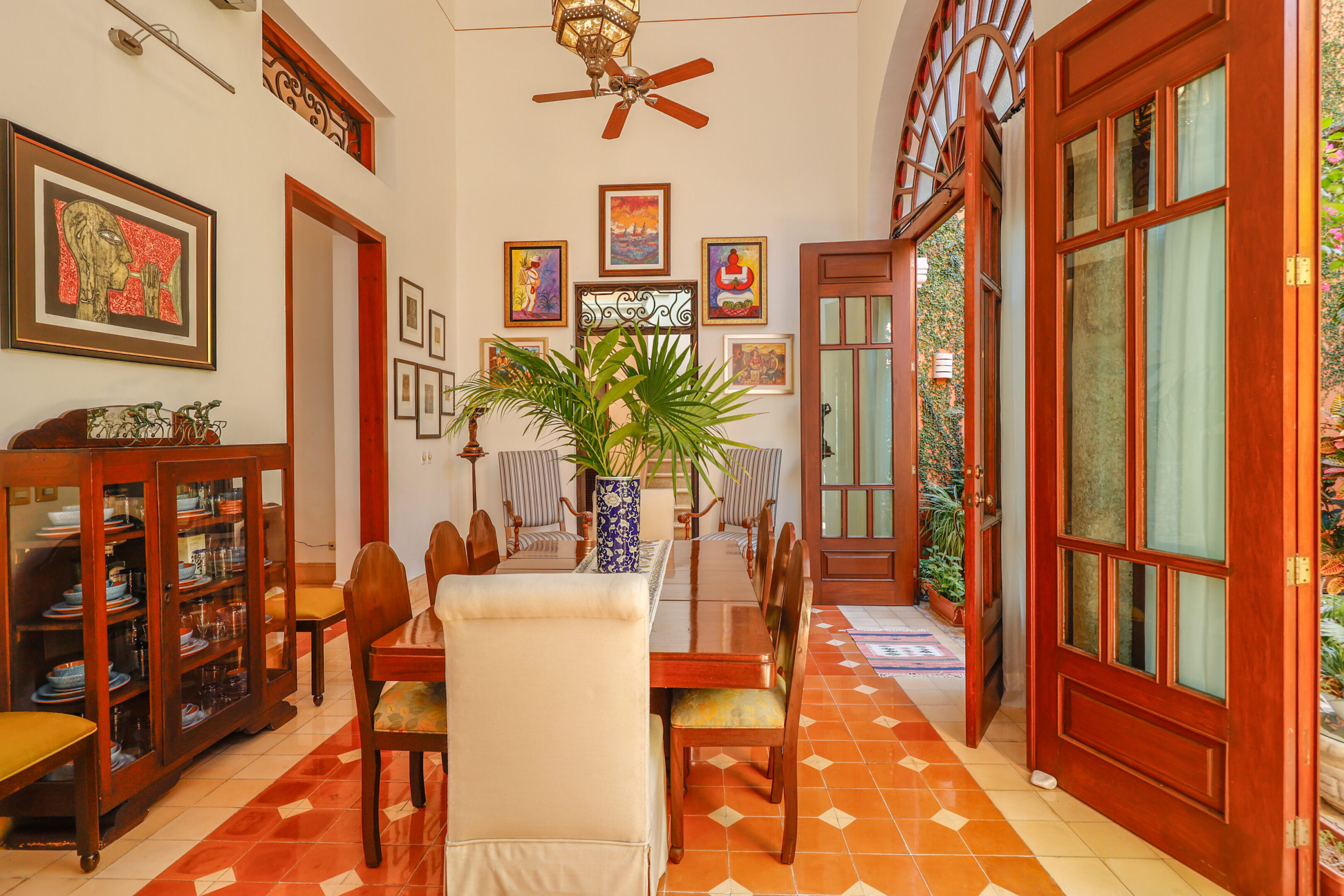 Dining room with artwork and wooden doors.