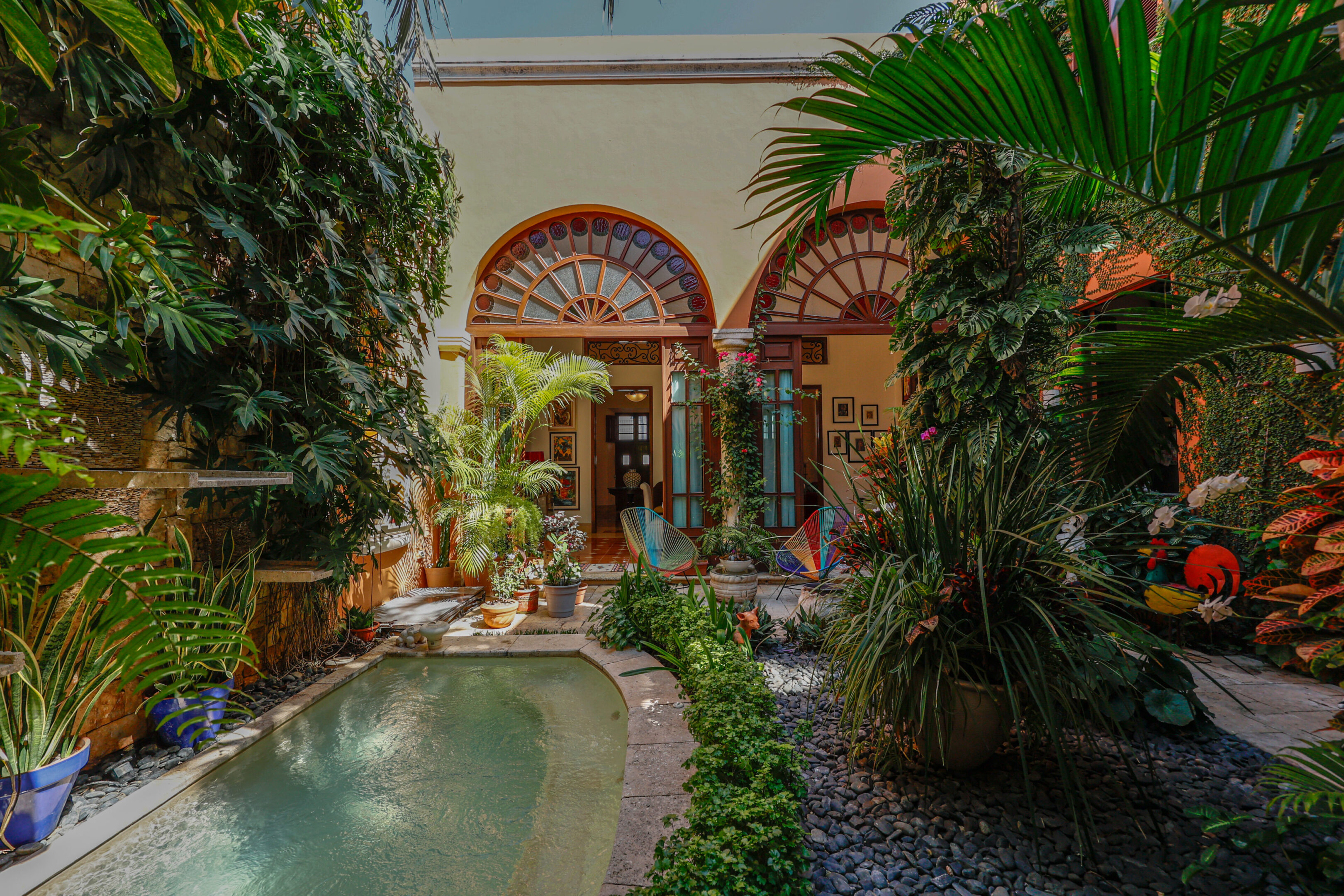 Lush courtyard with pool and arched doorways.