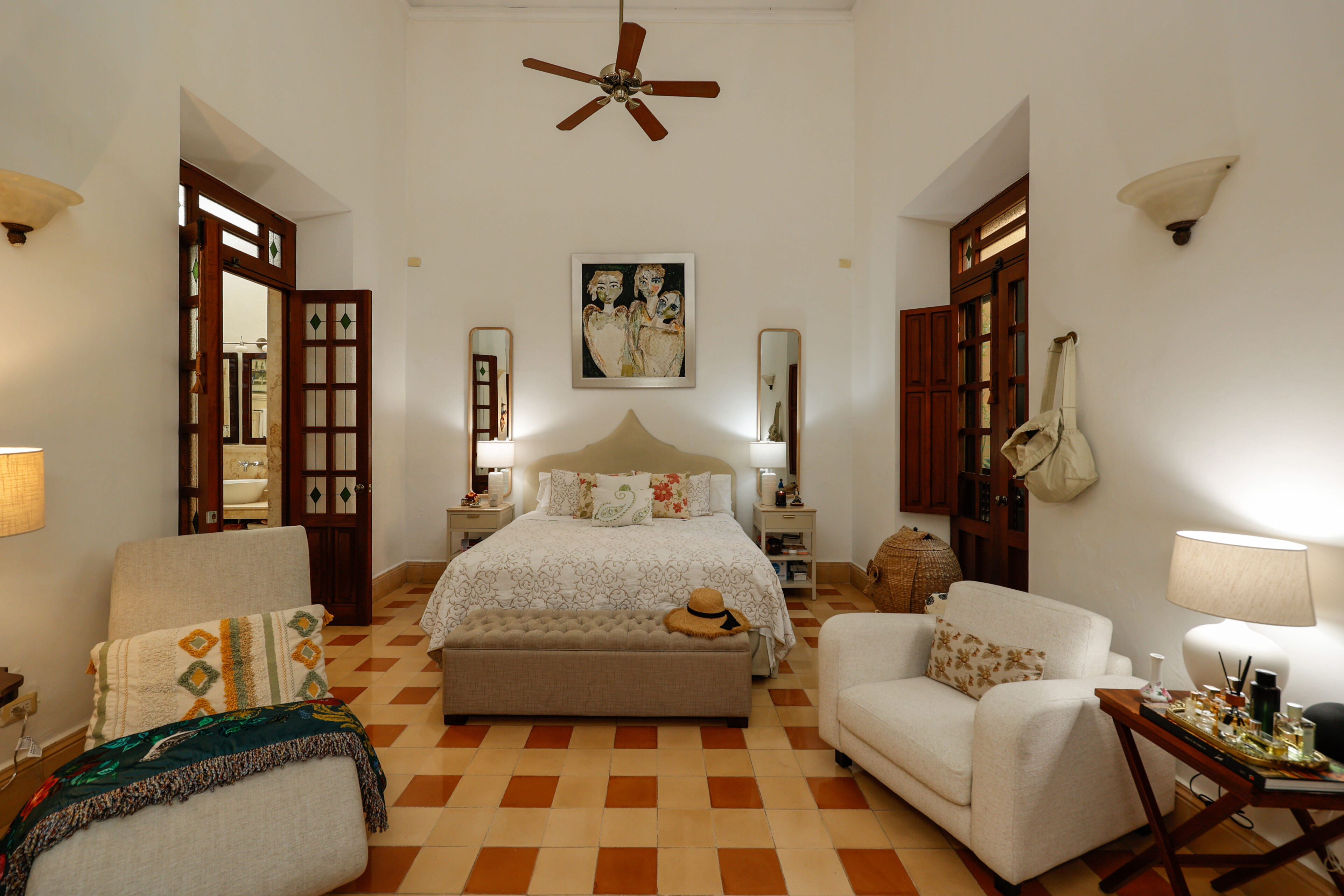 Bright bedroom with beige furniture and artwork.