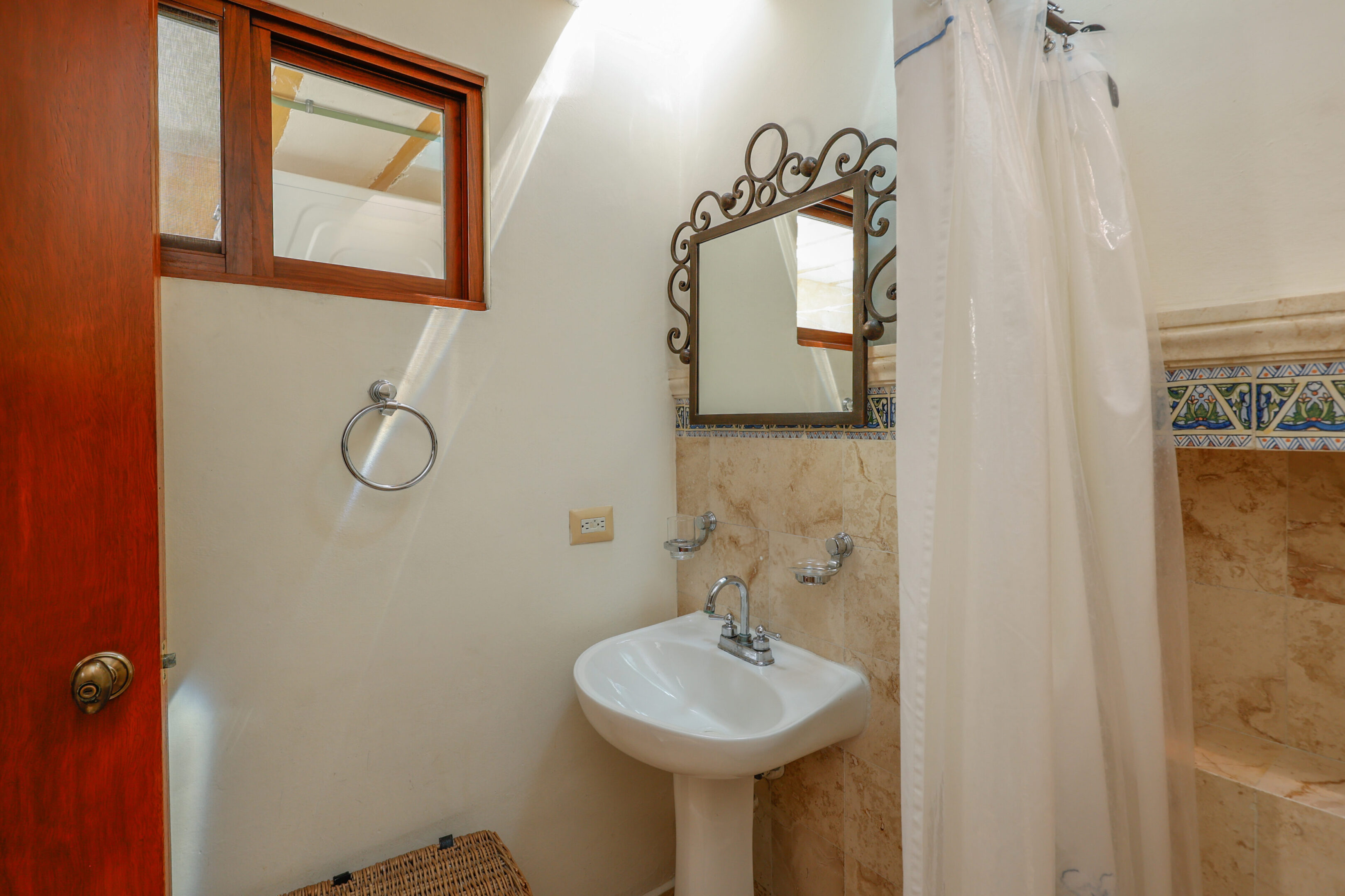 Small bathroom with pedestal sink and shower.