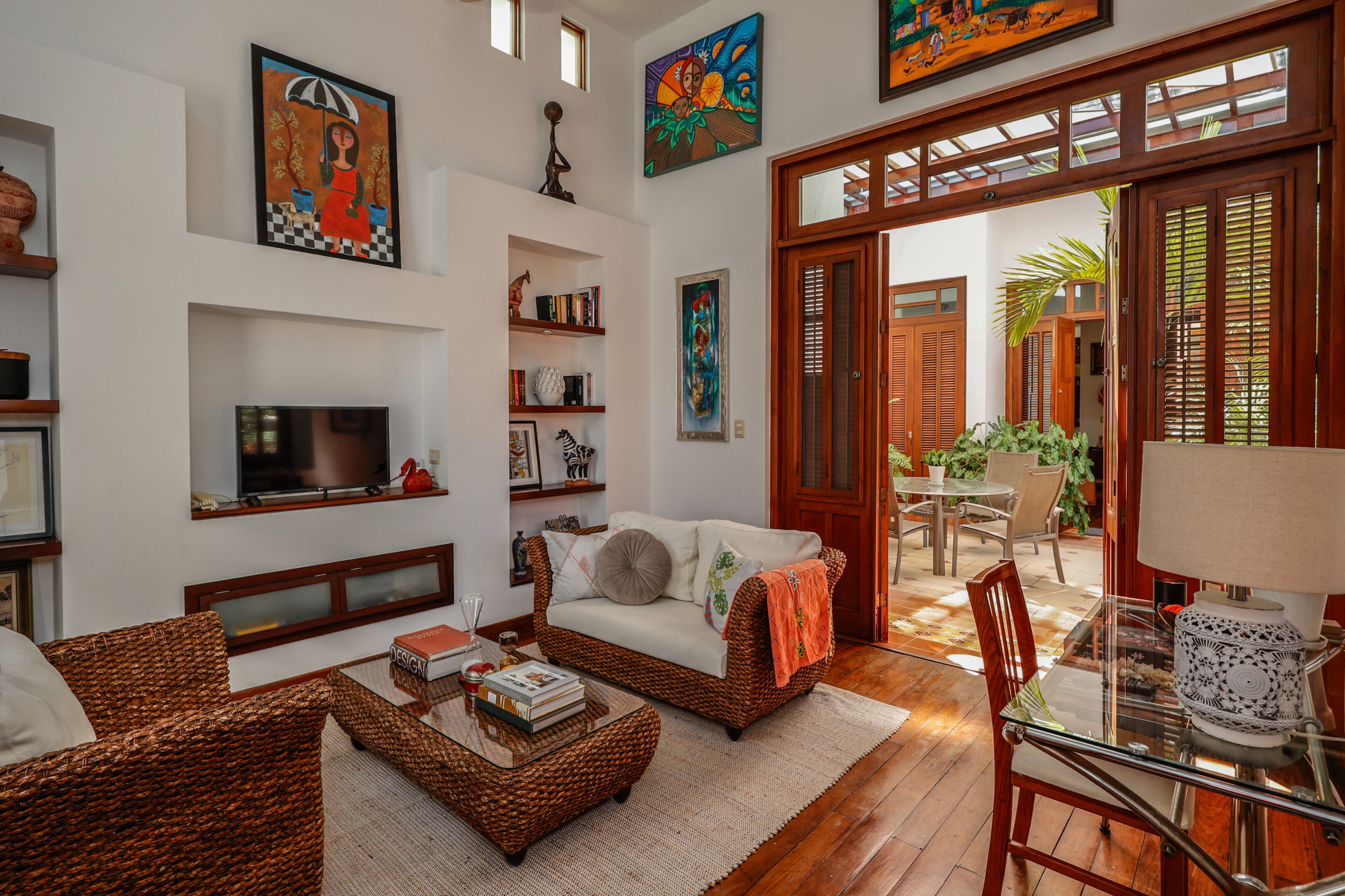 Cozy living room with wicker furniture and art.