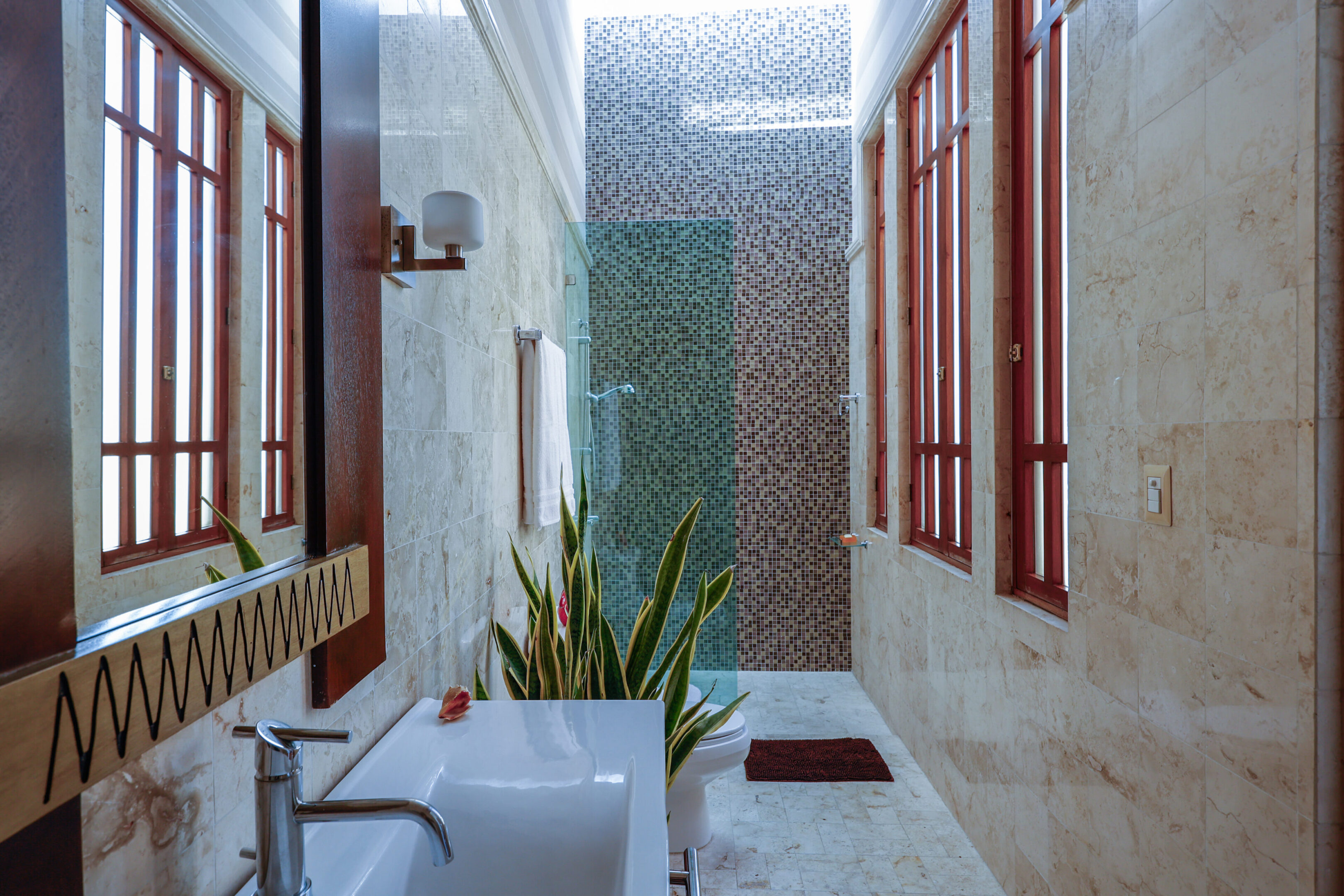 Luxurious bathroom with mosaic tile shower.