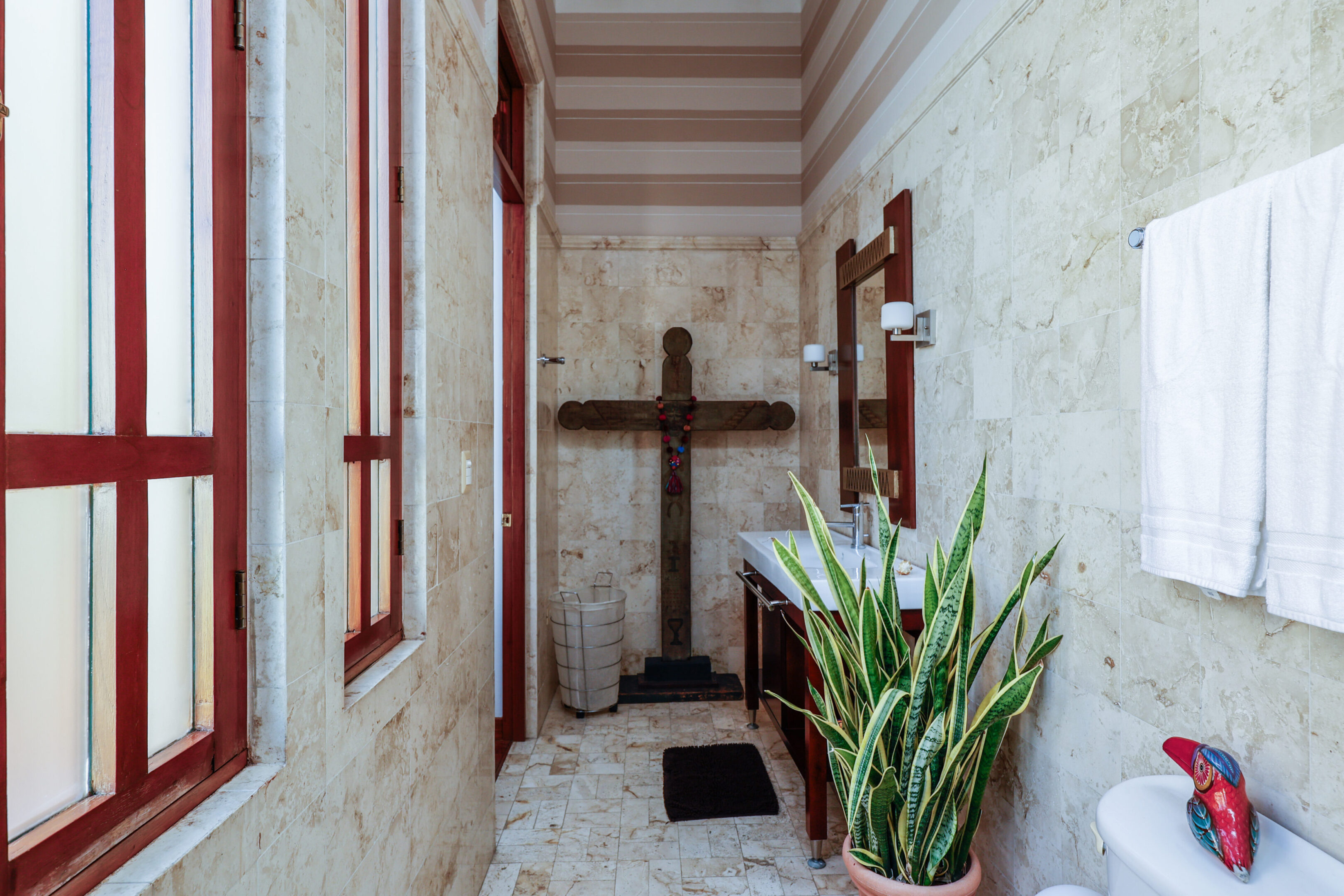 Bathroom with cross and plant.