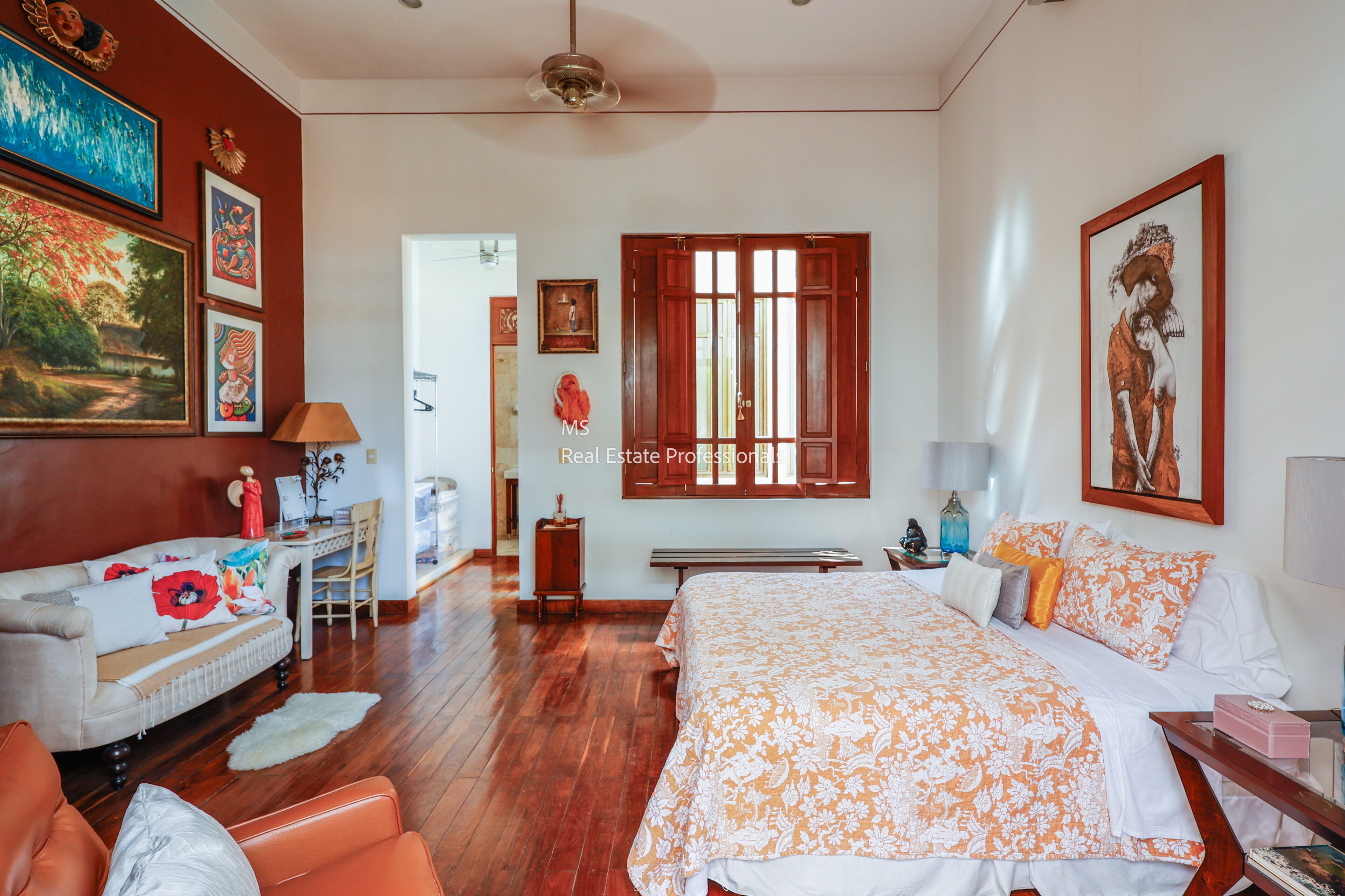 Bright bedroom with large bed and artwork.