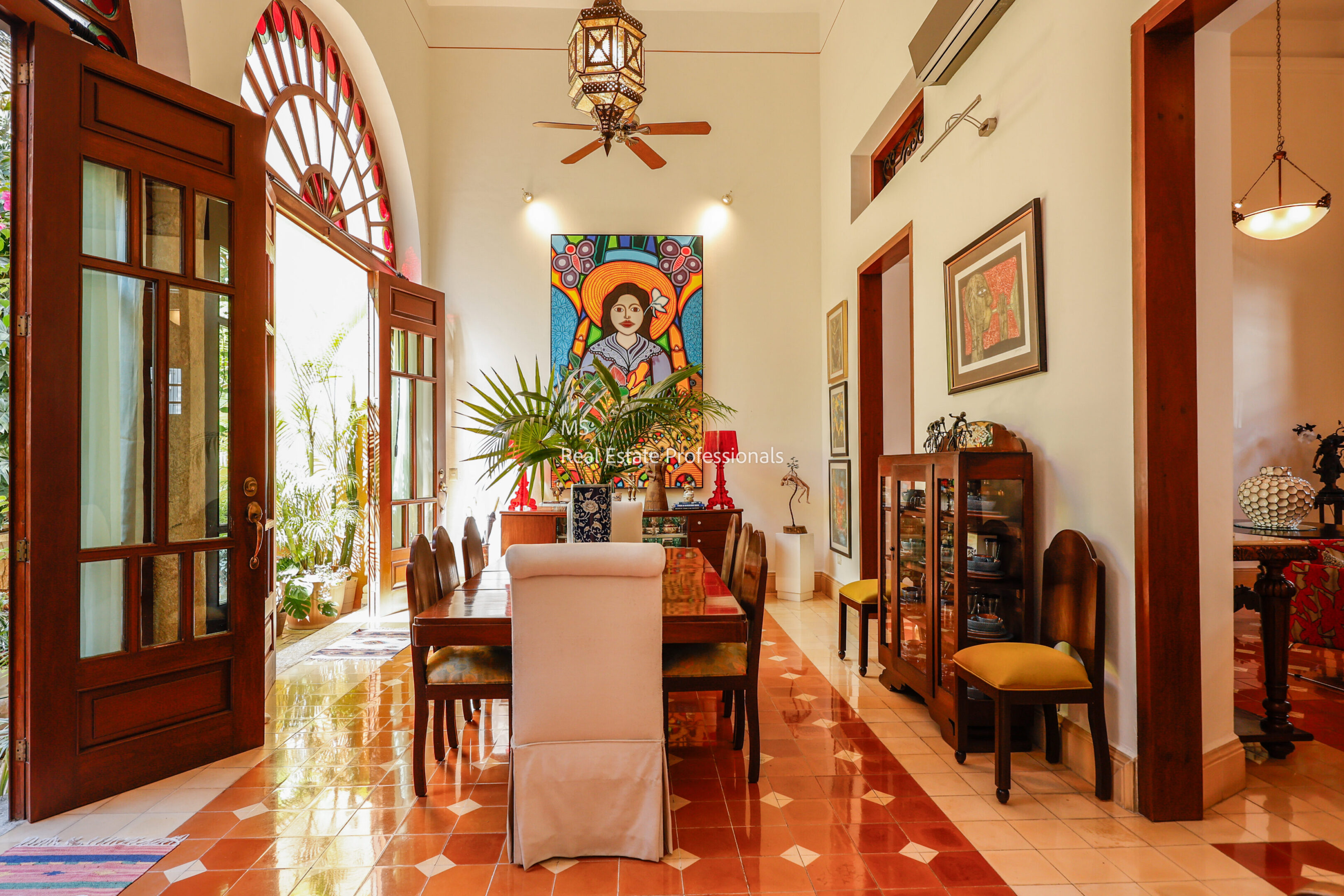 Dining room with colorful artwork and tiled floor.