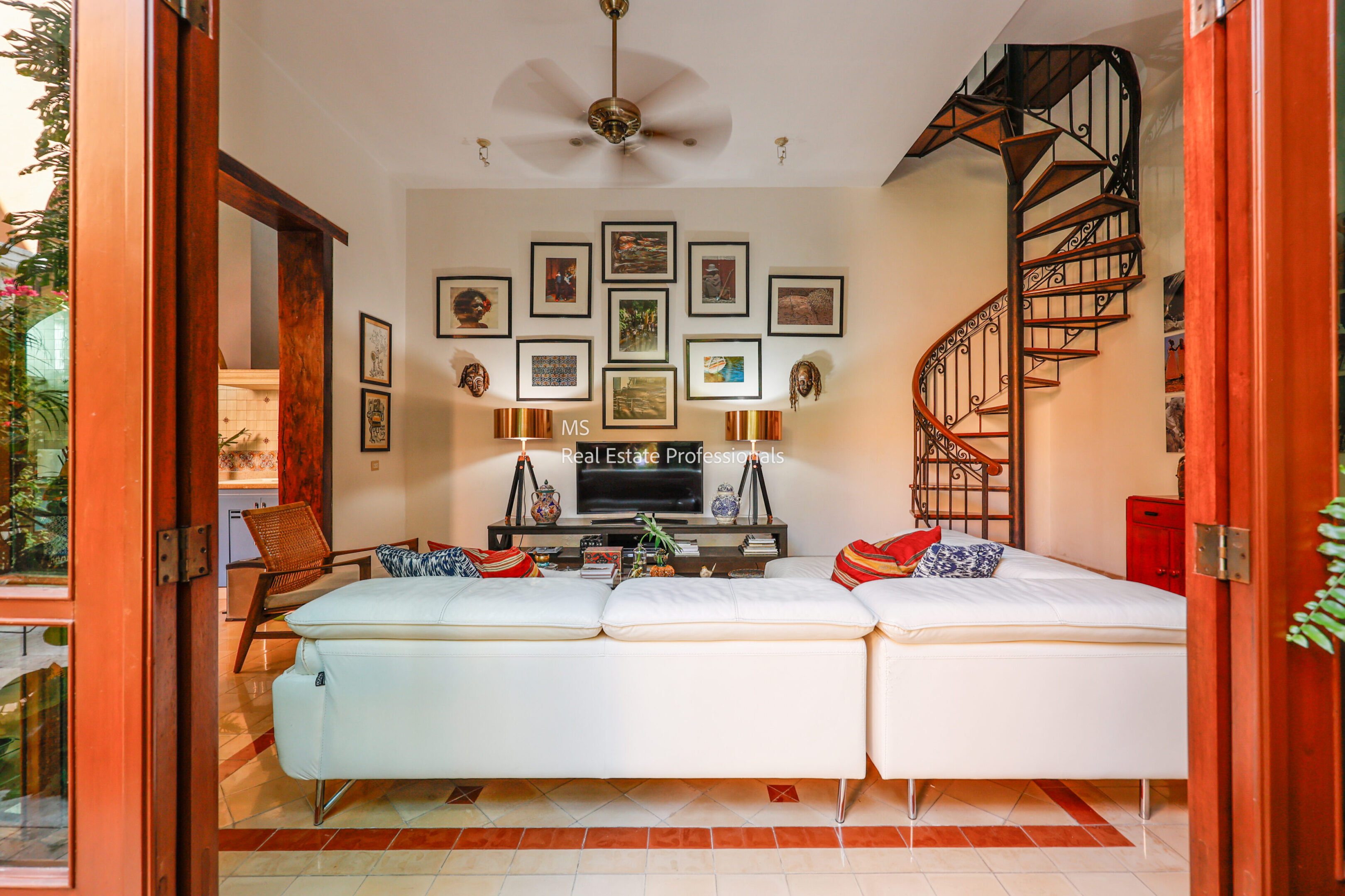 Here's an alt tag for the image: Modern living room with spiral staircase.