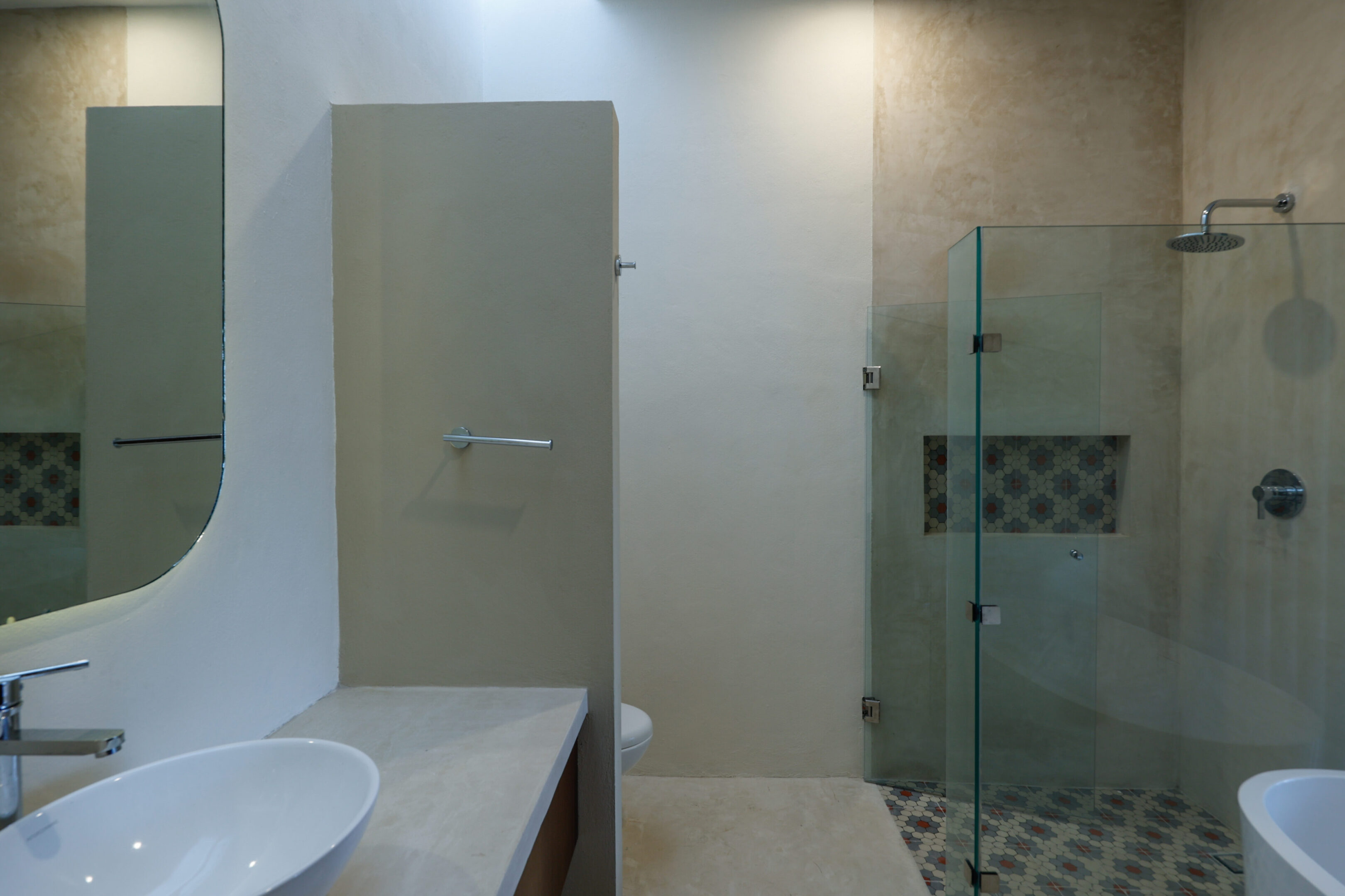 A modern bathroom with a glass shower enclosure and a sink counter.