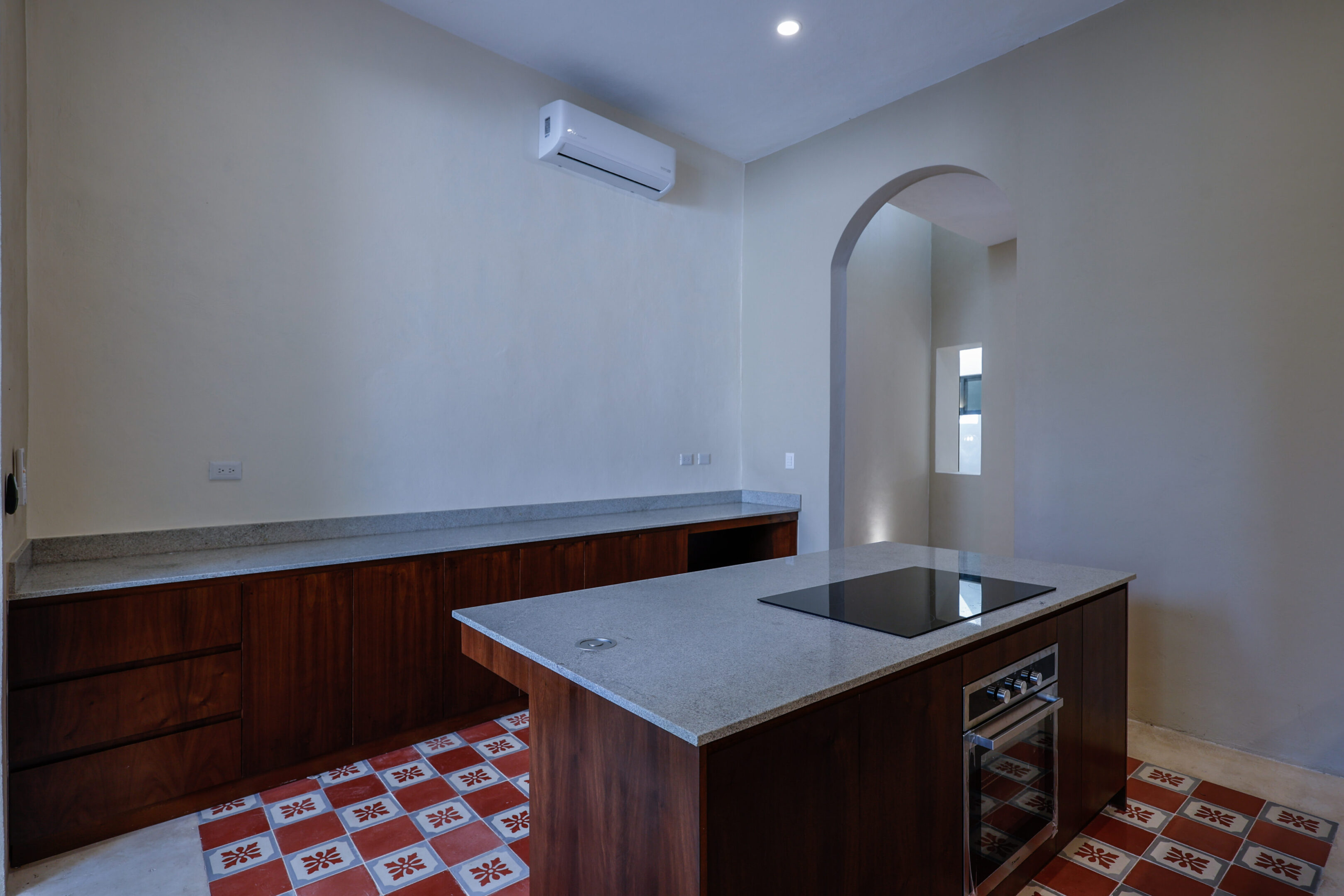 Modern kitchen with a central island and patterned floor tiles.
