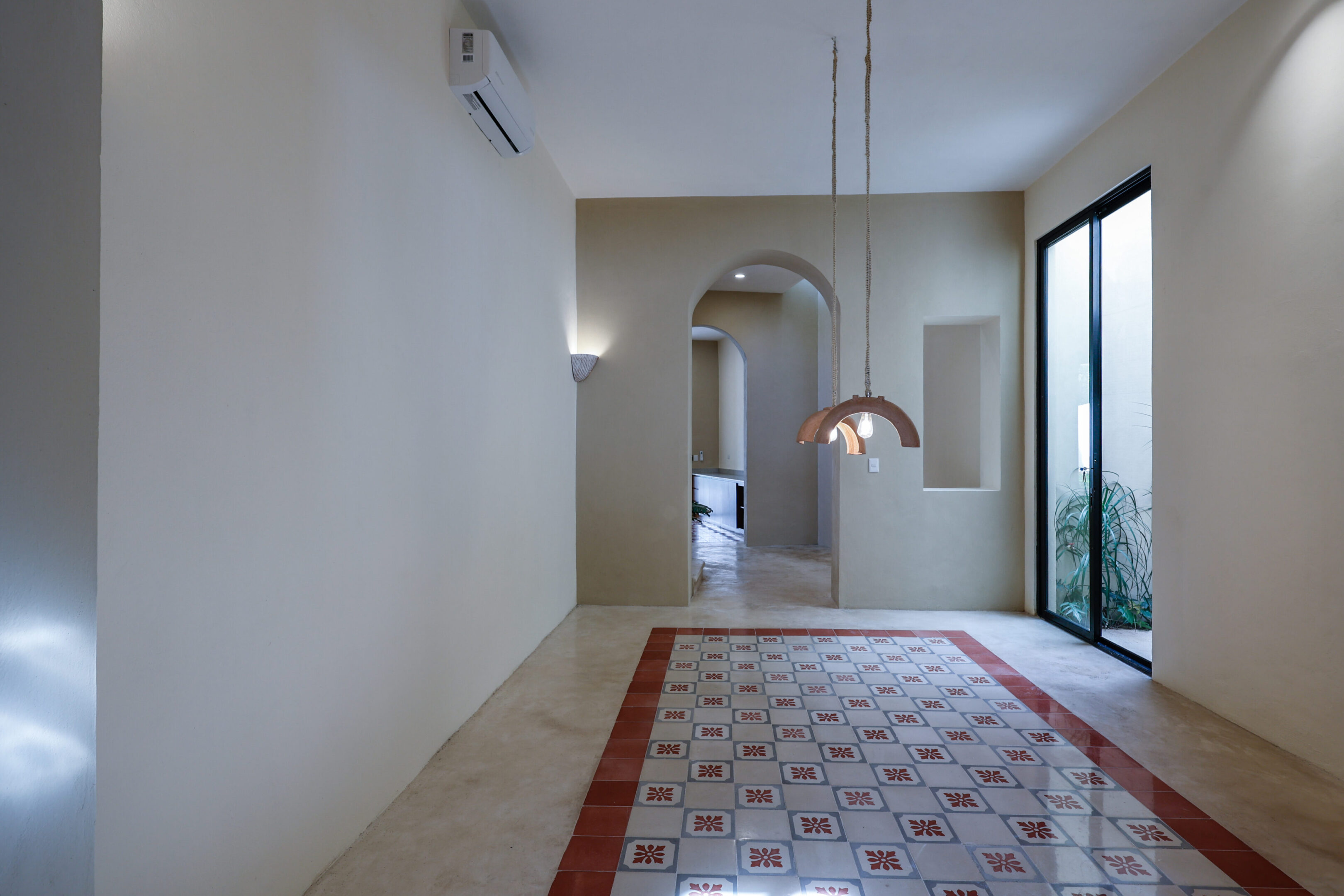 A modern hallway with a patterned tile floor and arched doorway.