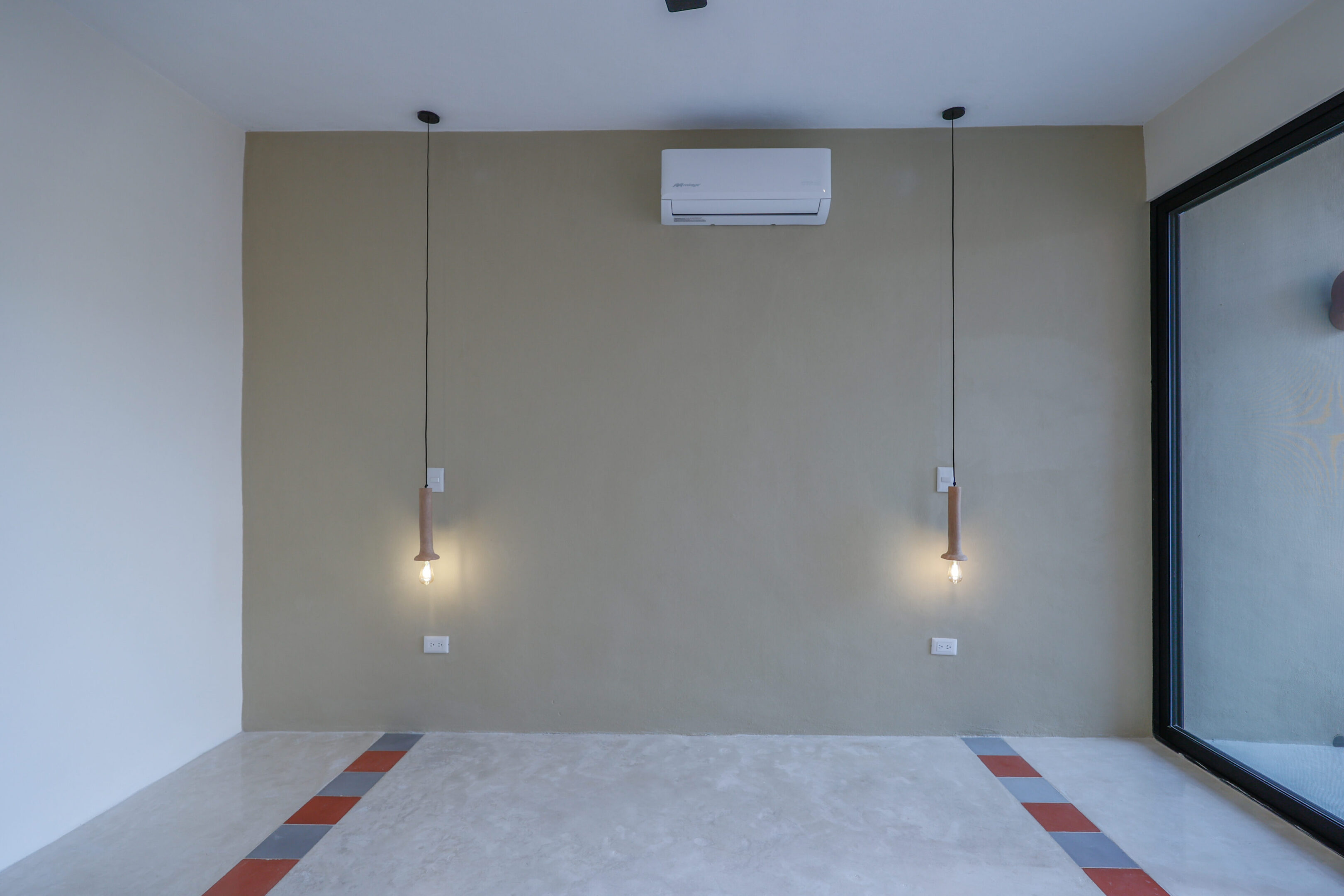 Minimalist room with hanging light bulbs and air conditioner.