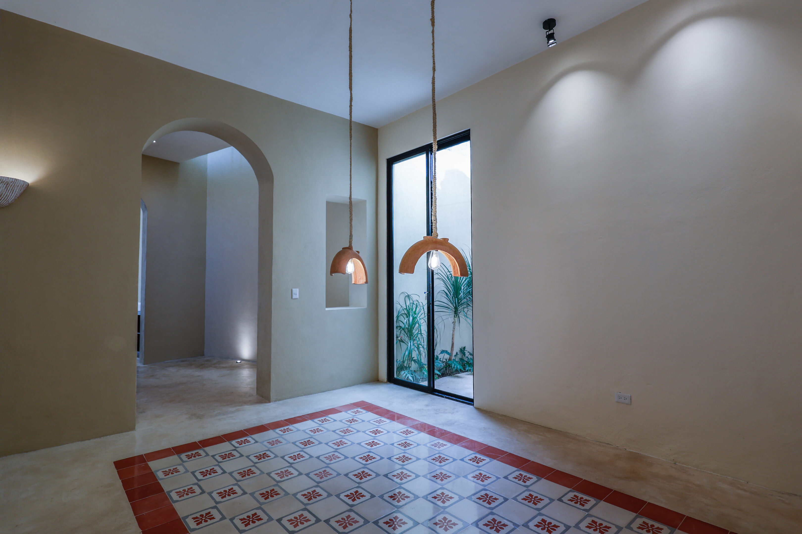 Minimalist room with pendant lights and patterned floor tiles.