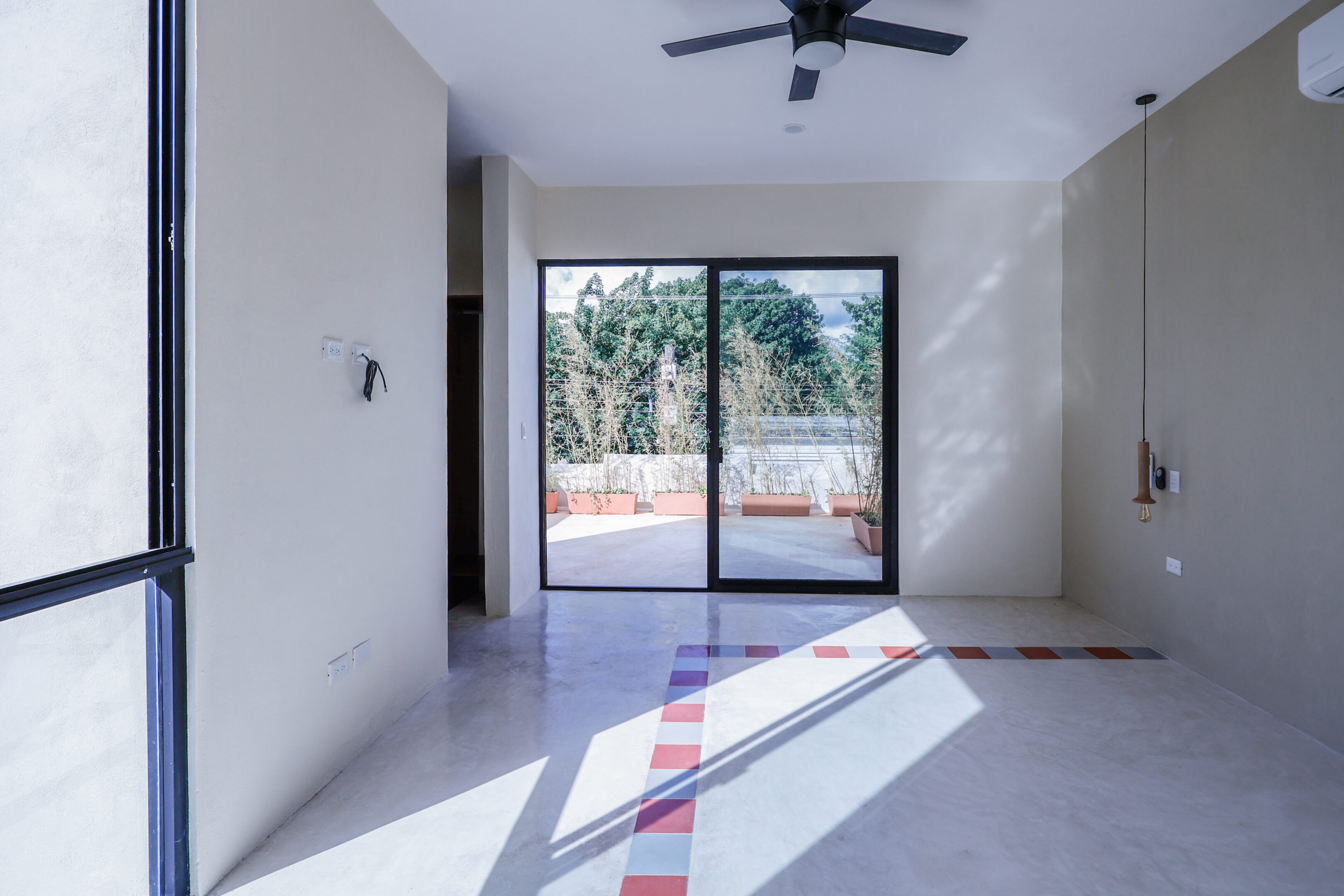 Bright room with large sliding glass doors and ceiling fan.