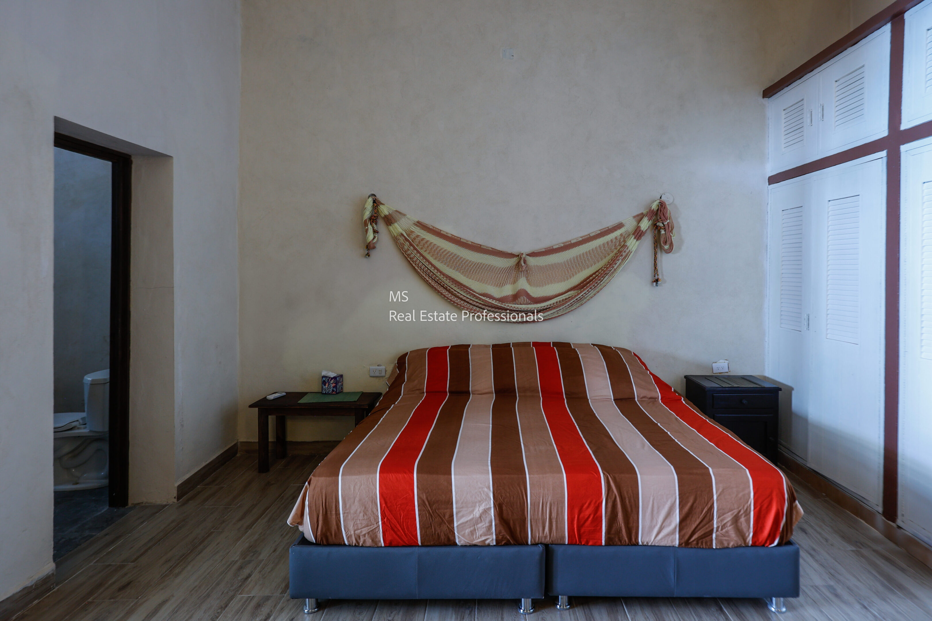 Bed with red and brown striped blanket in a cozy room.