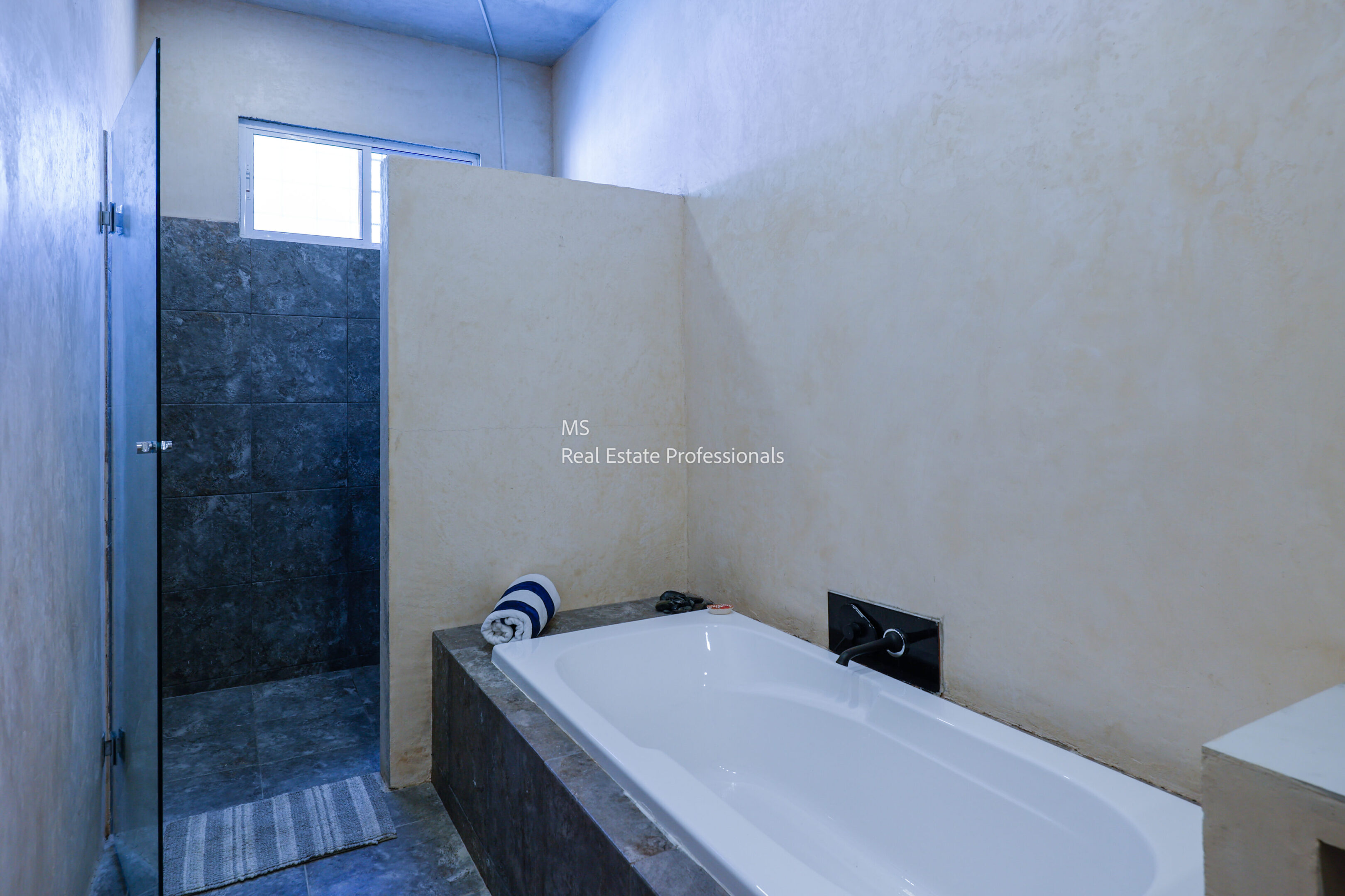 Modern bathroom with a bathtub and towel.