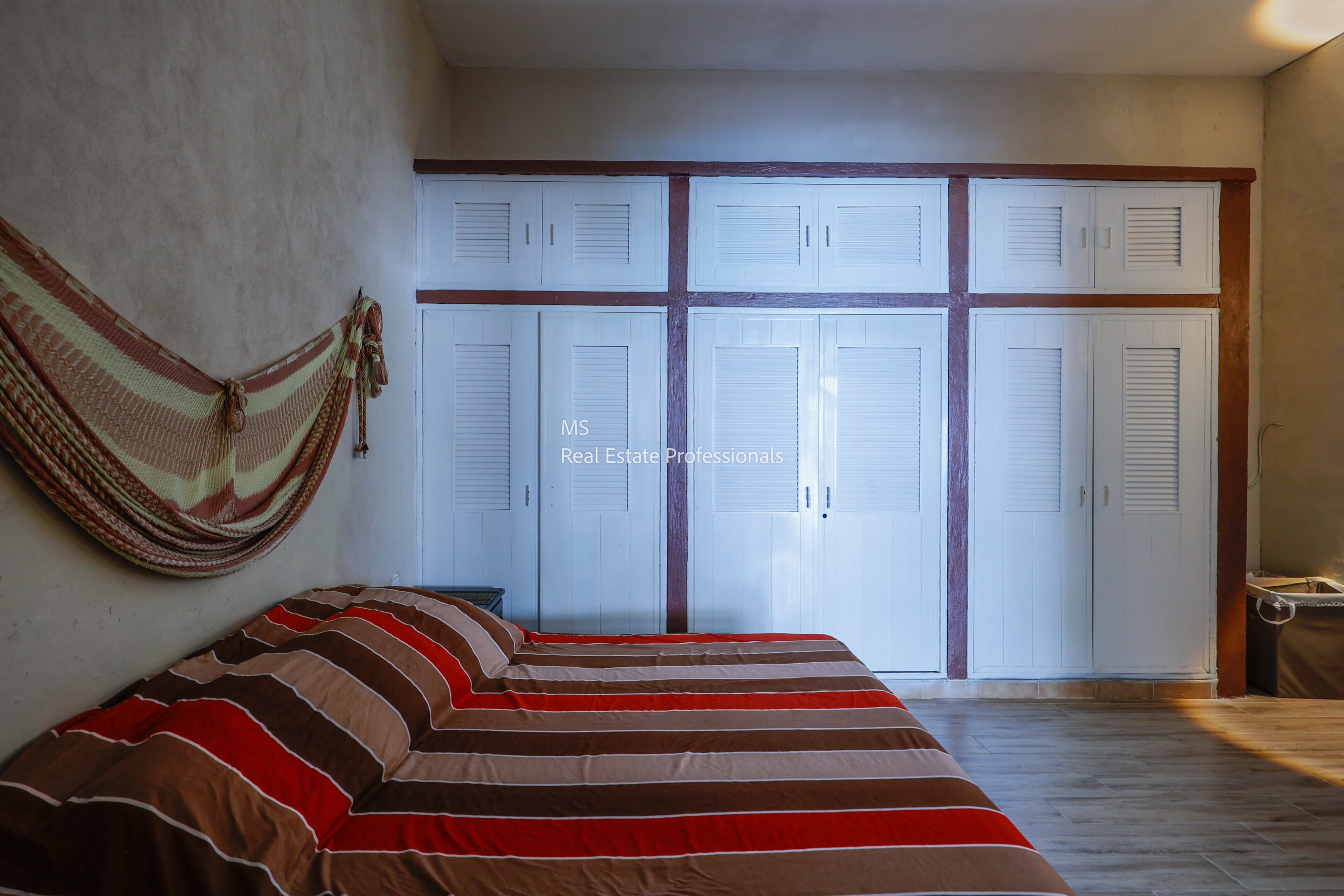A cozy room with a striped bedspread and frosted windows.