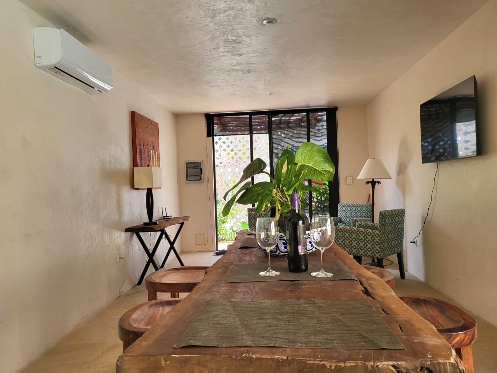 Cozy dining room with rustic wooden table and large windows.