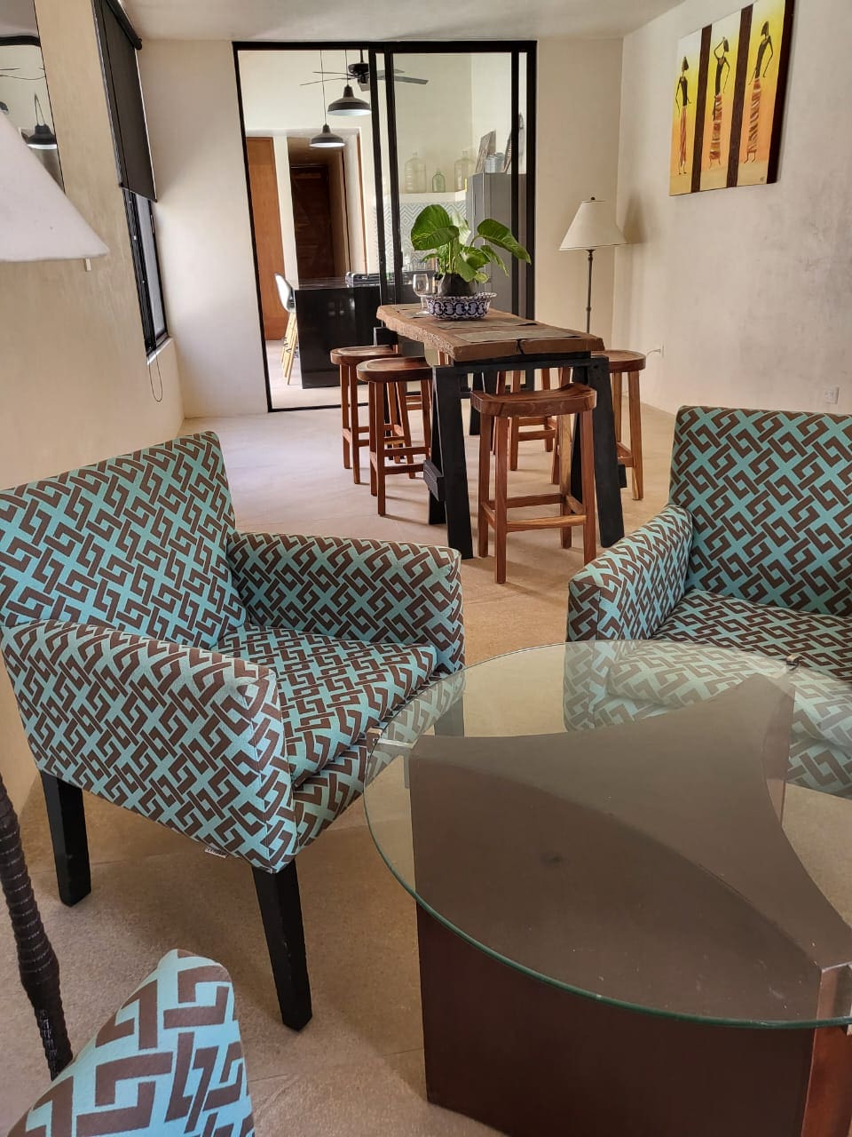 Cozy living room with patterned chairs and a glass coffee table.