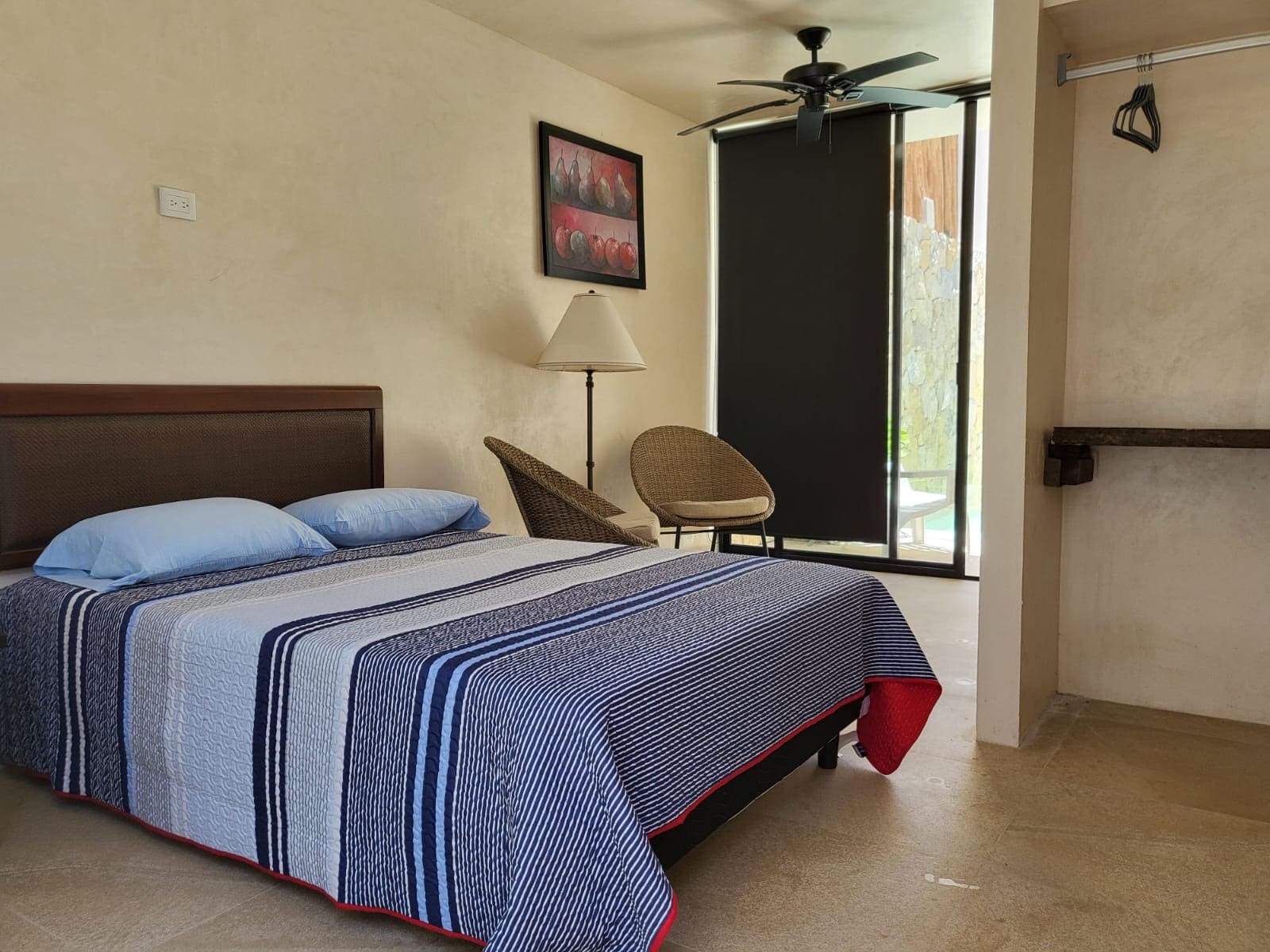 A neatly made bed with a blue striped bedspread in a cozy bedroom.
