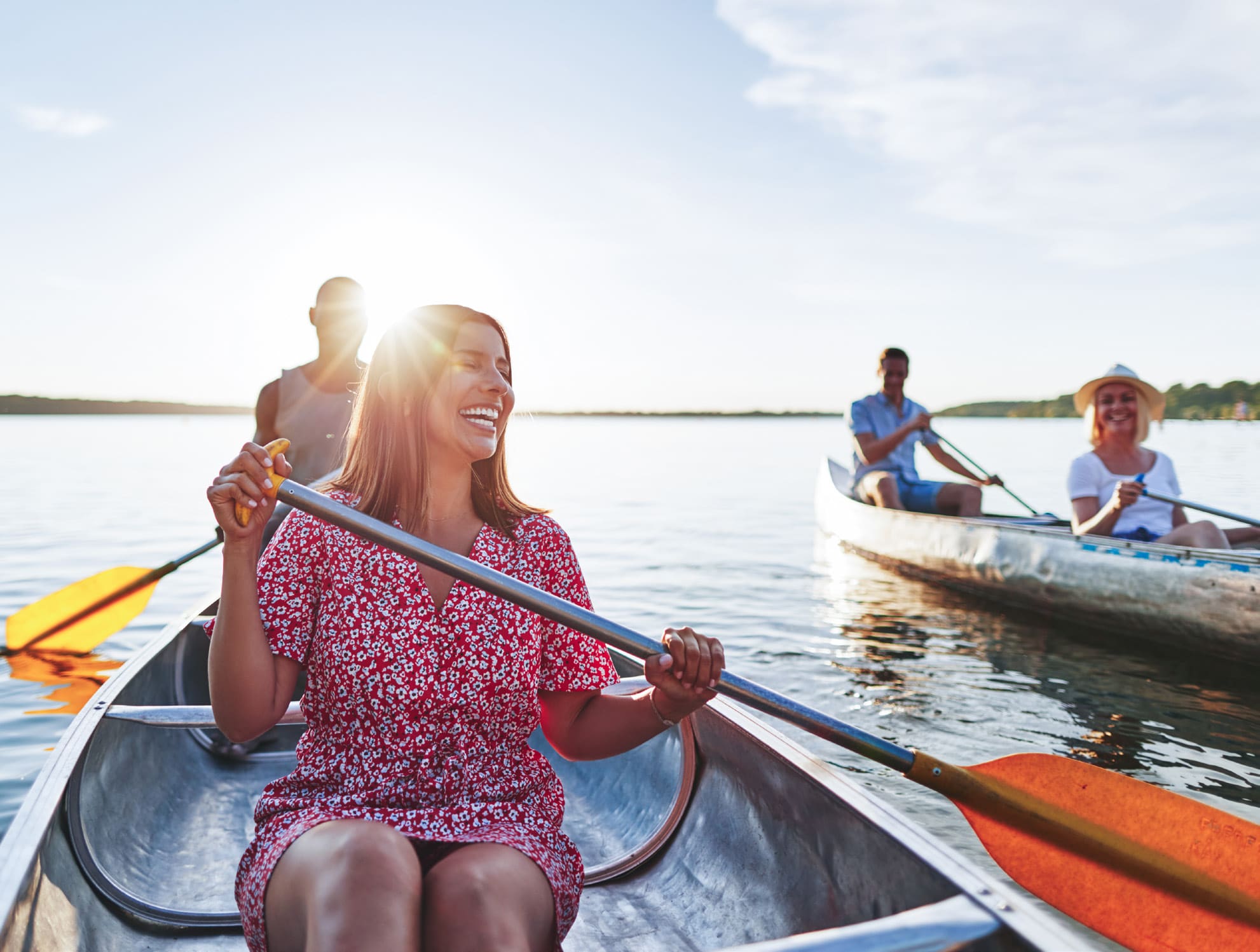 Two people enjoying rowing boats on a sunny lake.