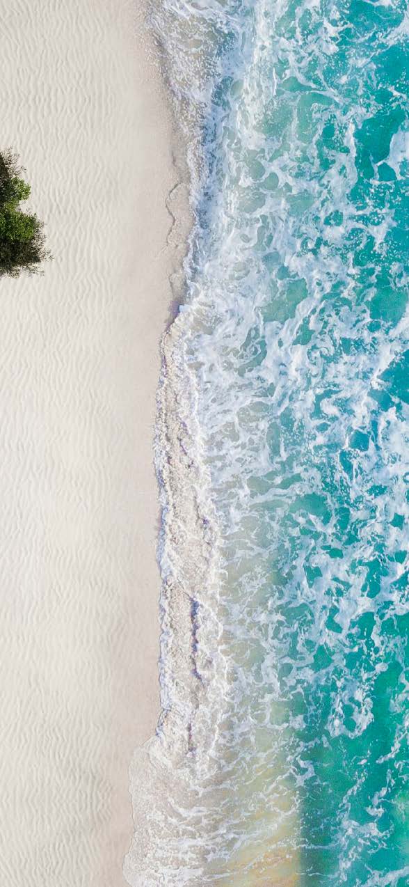 Aerial view of ocean waves hitting a sandy beach.