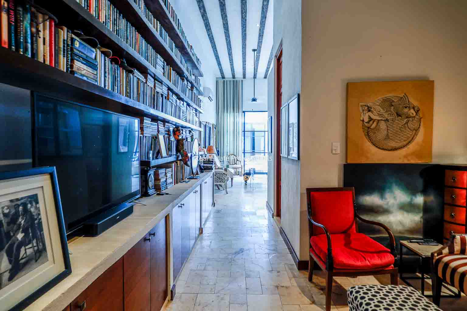 Cozy reading nook with bookshelves and a red chair.