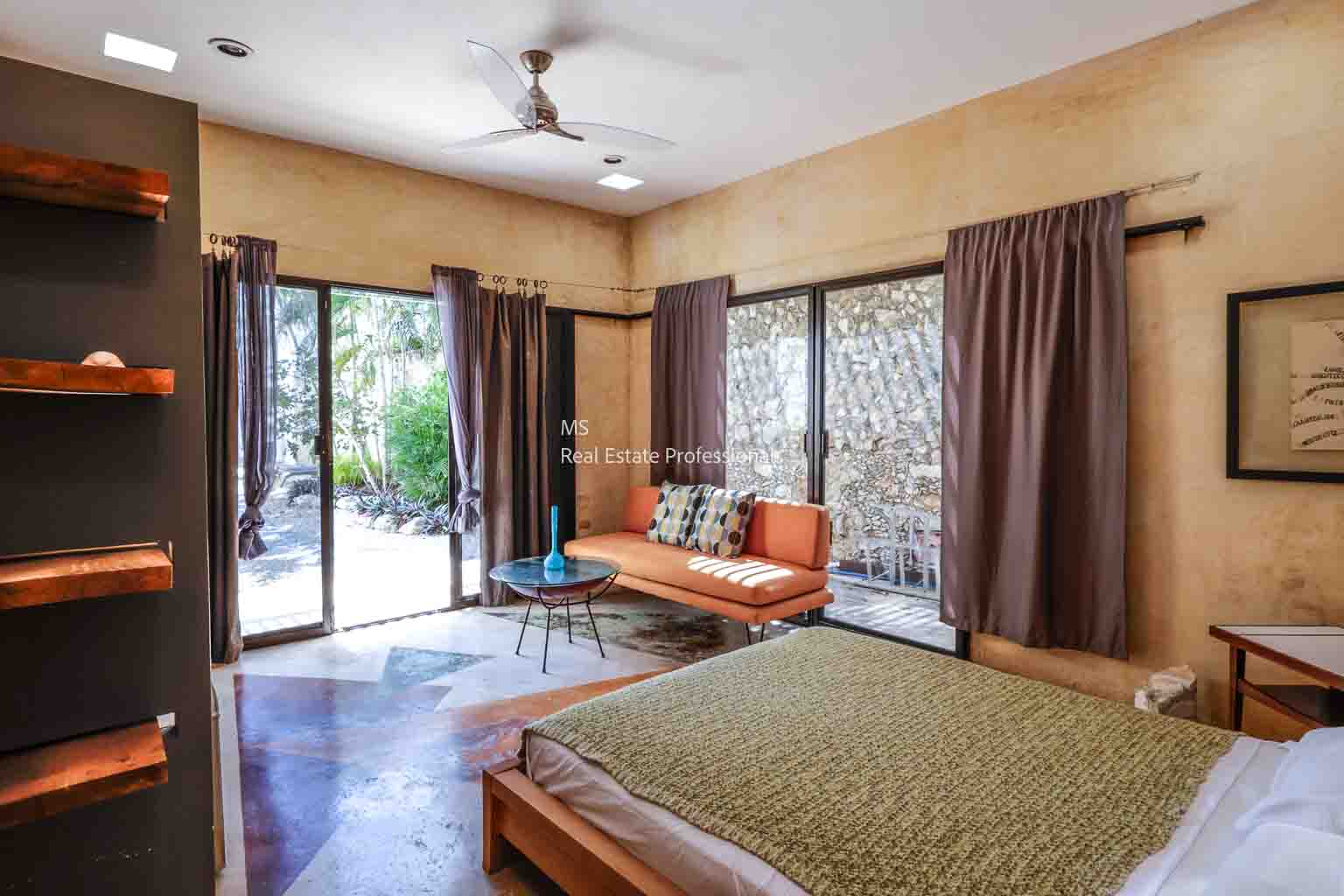 Cozy room with open doors to a garden and warm decor.