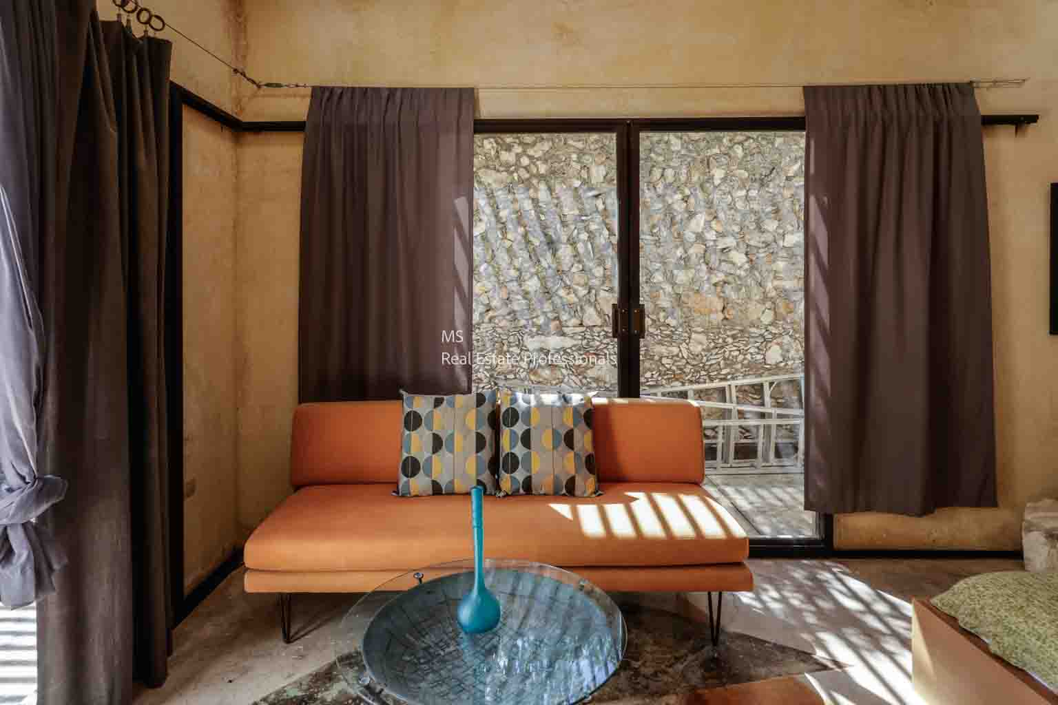 Modern living room with orange sofa and glass table.