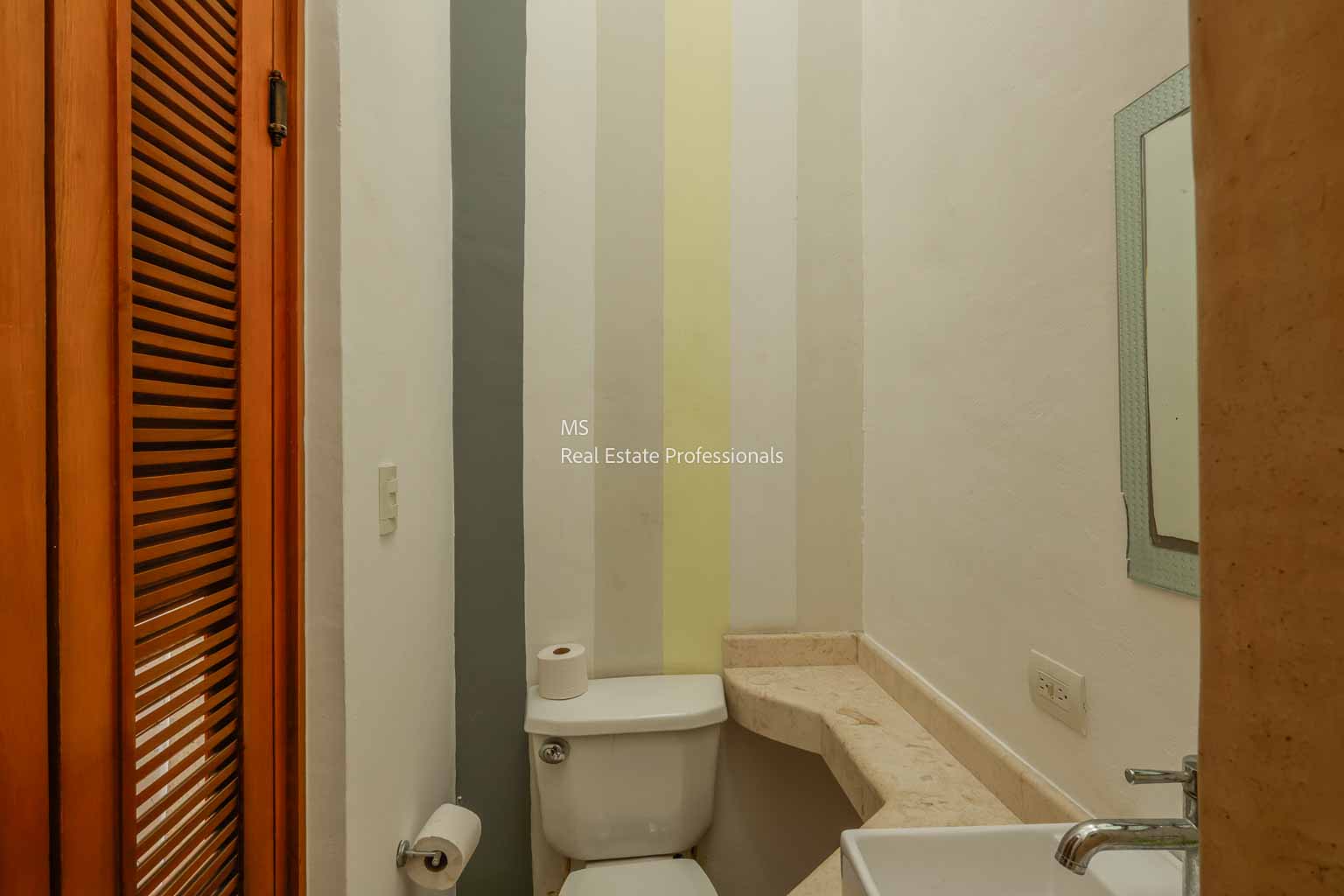 Small bathroom with a toilet, sink, and yellow striped wall.