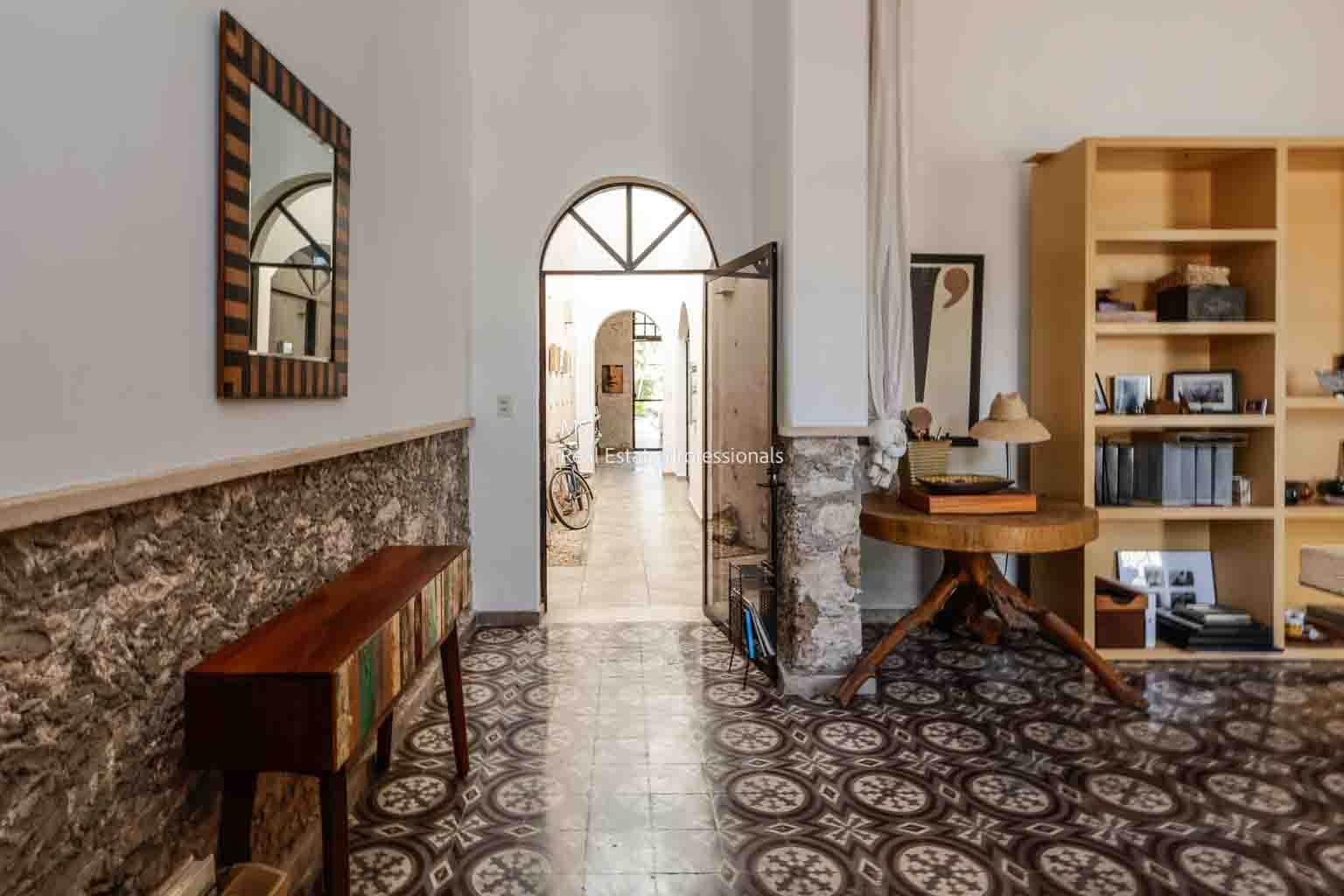 Elegant vintage hallway with patterned floor and wooden furniture.