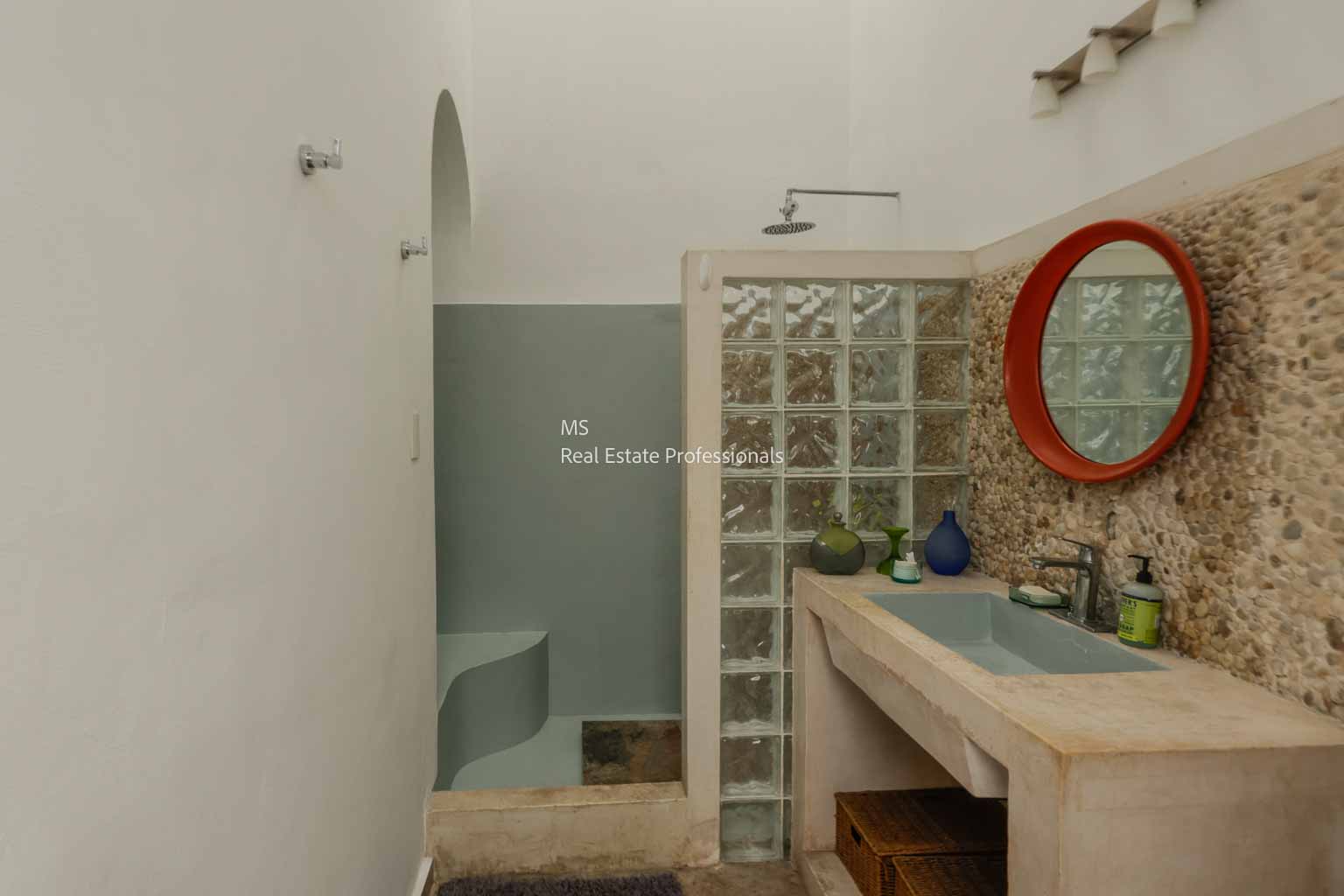 Modern bathroom with glass block shower and wooden vanity.