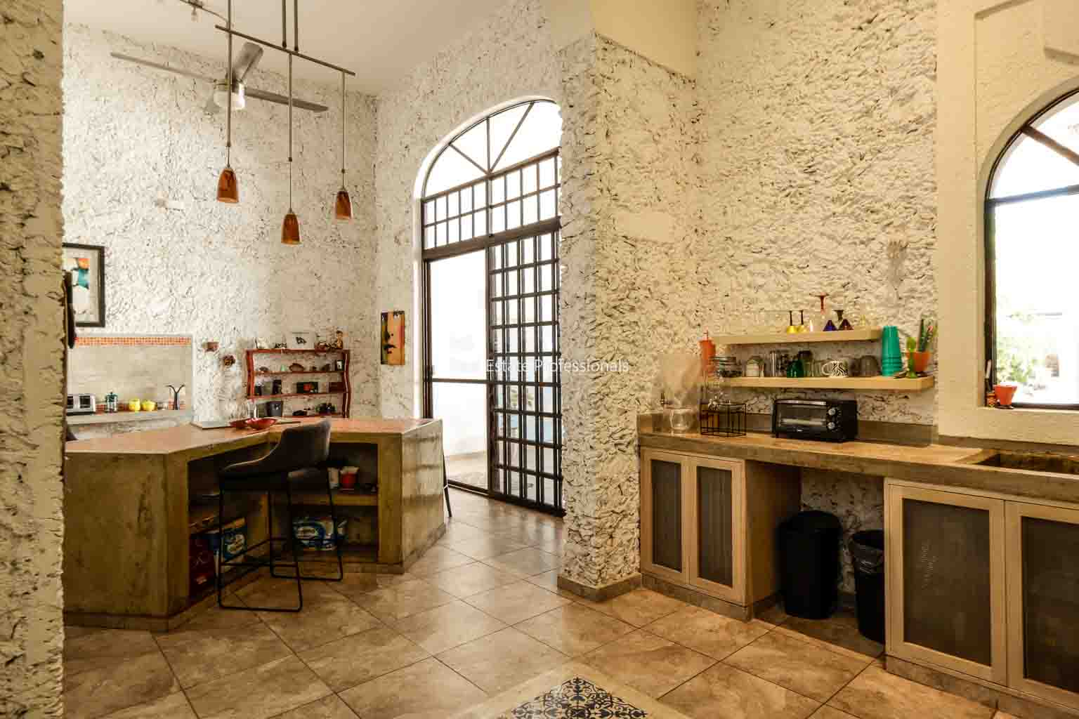 Rustic kitchen with exposed brick walls and wooden furniture.