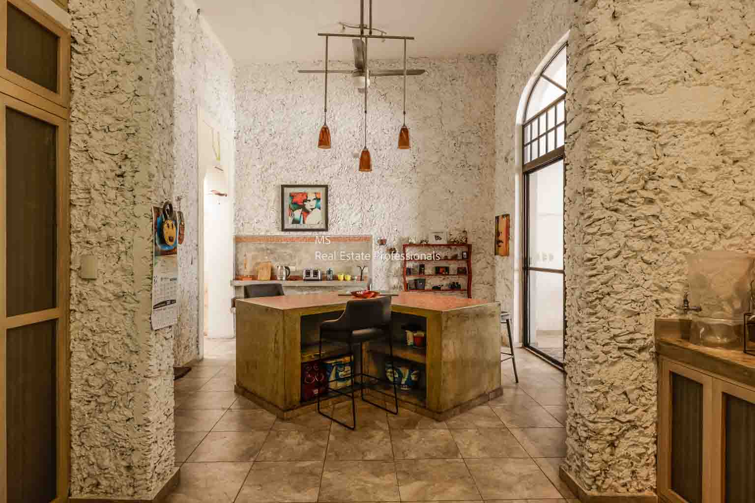 Cozy, rustic kitchen with wooden island and hanging lights.