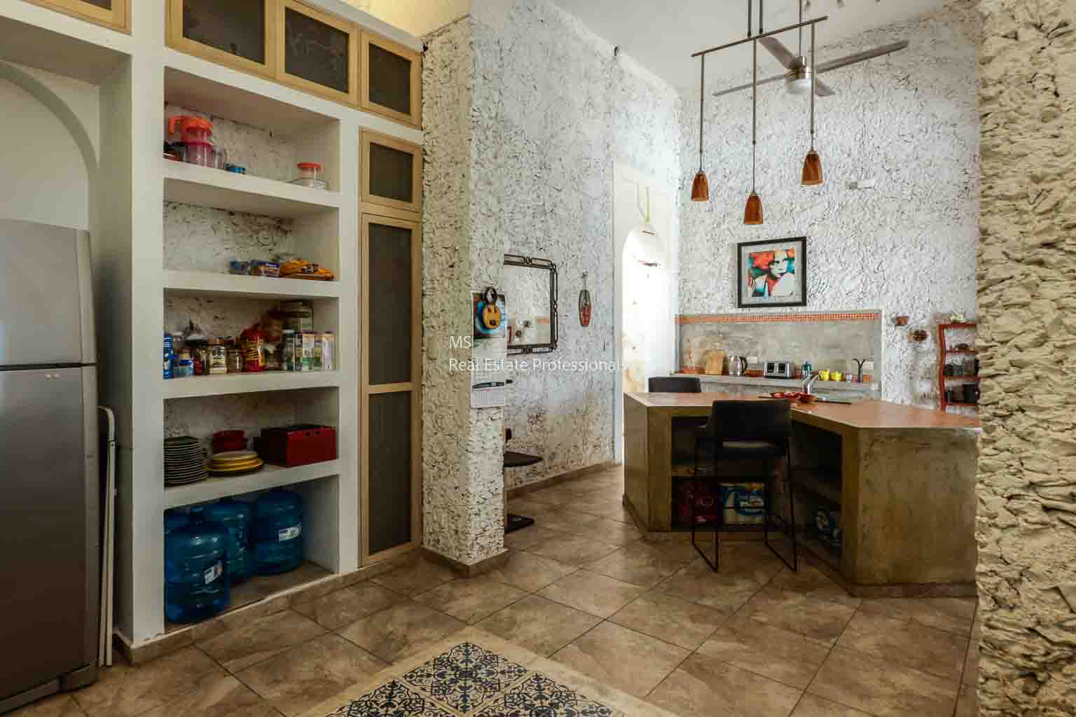 Cozy rustic kitchen with wooden shelves and vintage decor.
