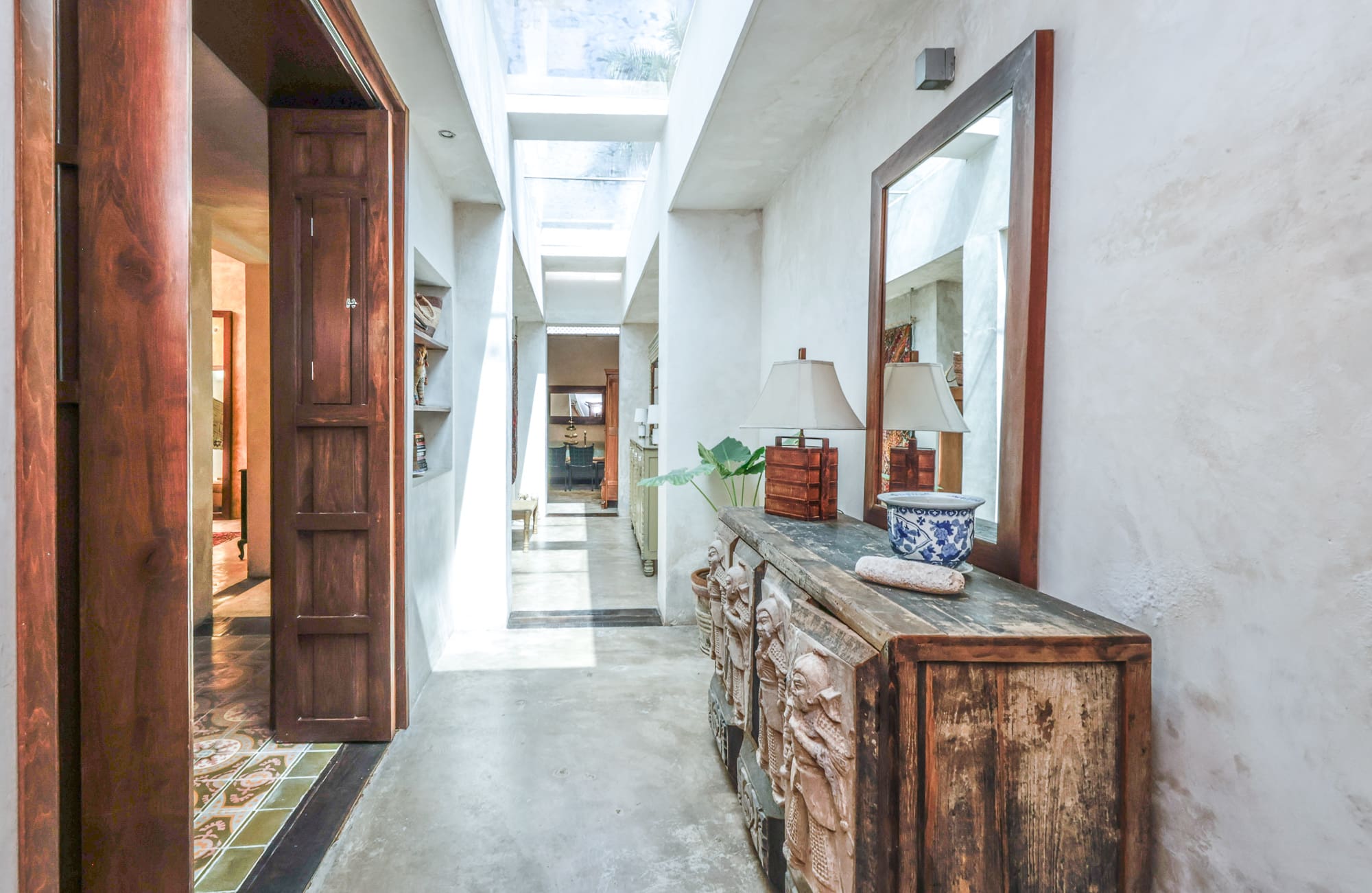 Bright hallway with rustic wooden furniture and skylights.