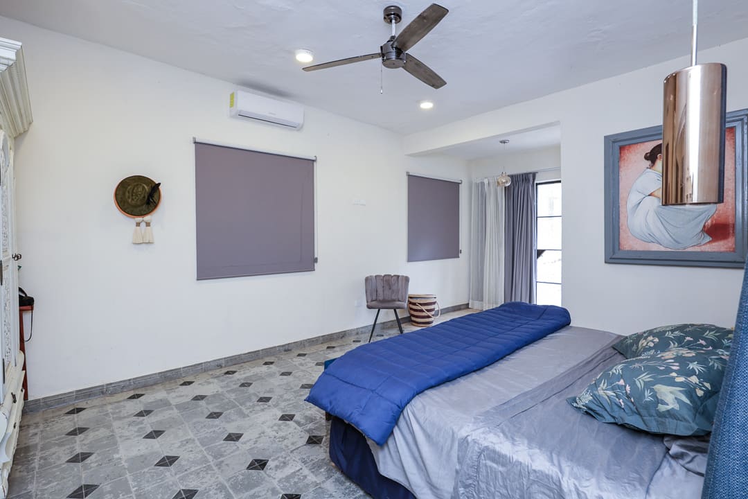 Minimalist bedroom with gray walls and patterned floor tiles.