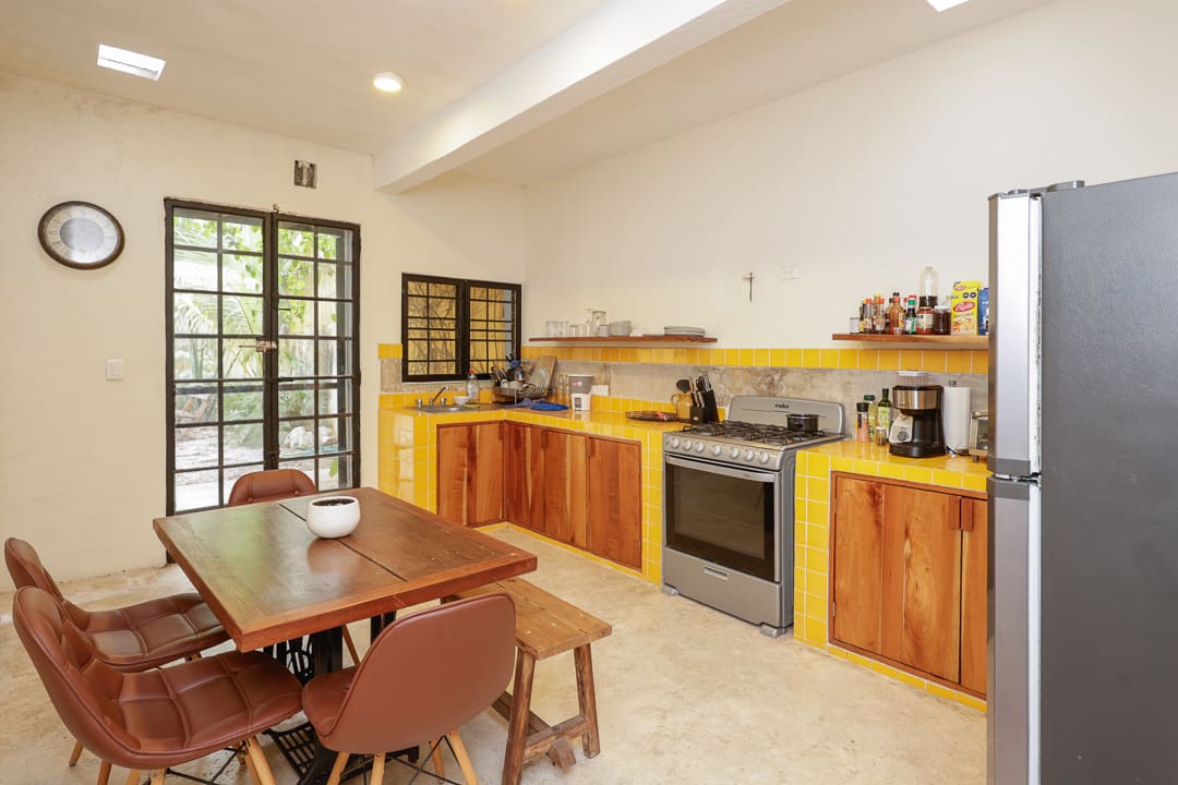 Cozy kitchen with wooden cabinets and dining area in natural light.