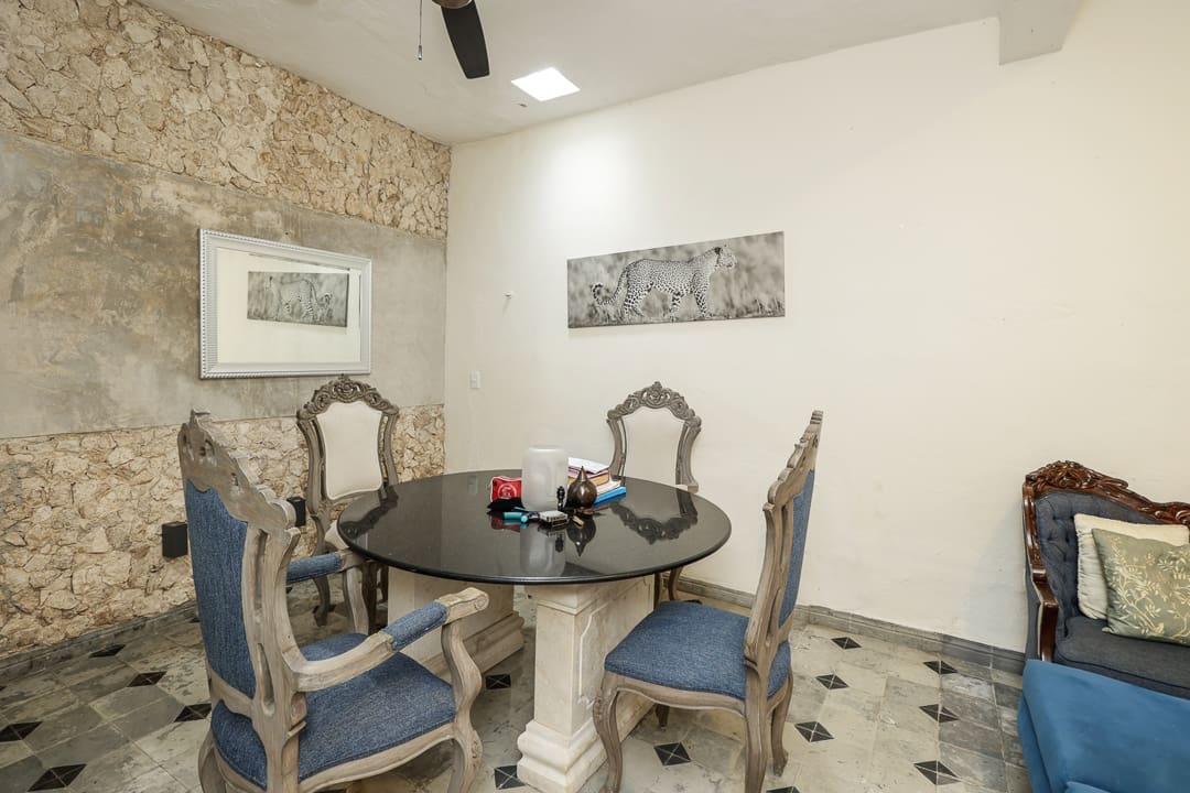 Elegant dining room with antique chairs and a round table.